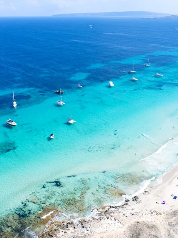 a beach with boats in the water
