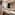 Modern bathroom double vanity with white vessel sinks, black faucets, backlit mirror.