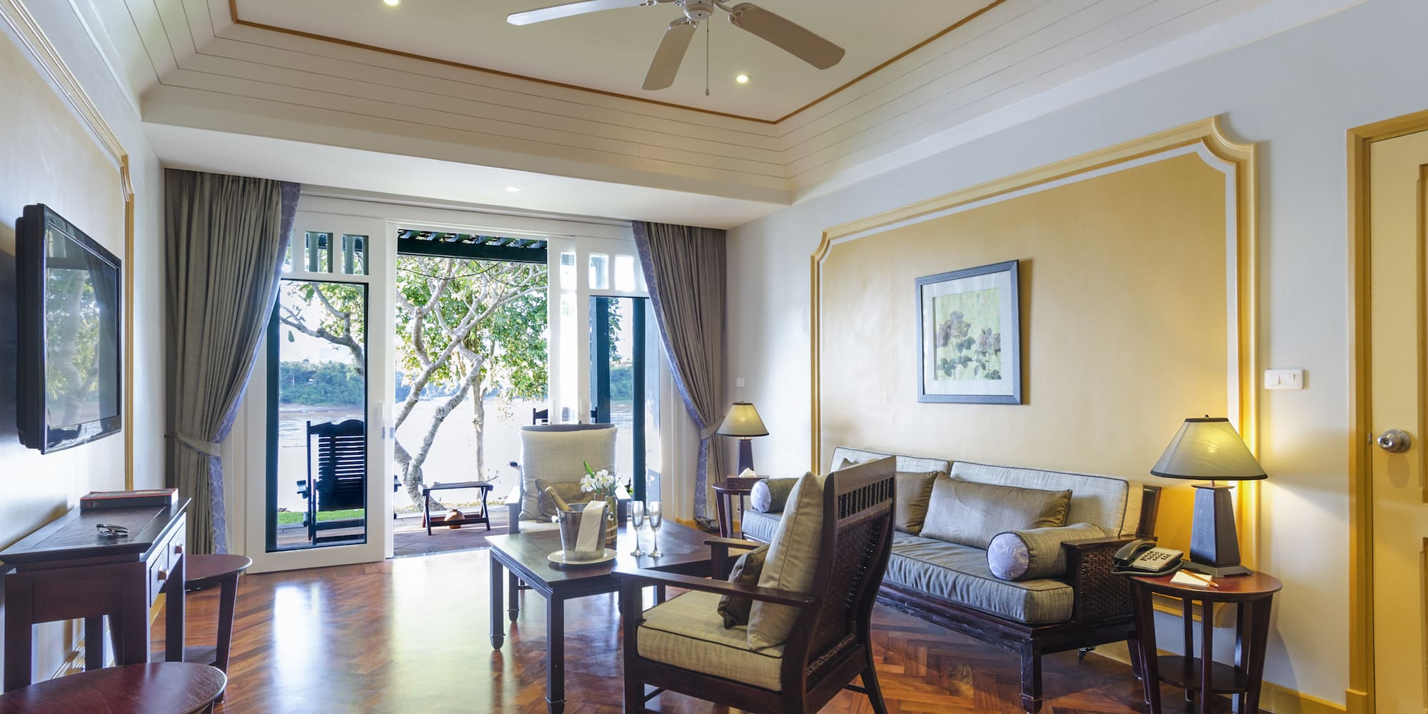 a living room with a ceiling fan and couches