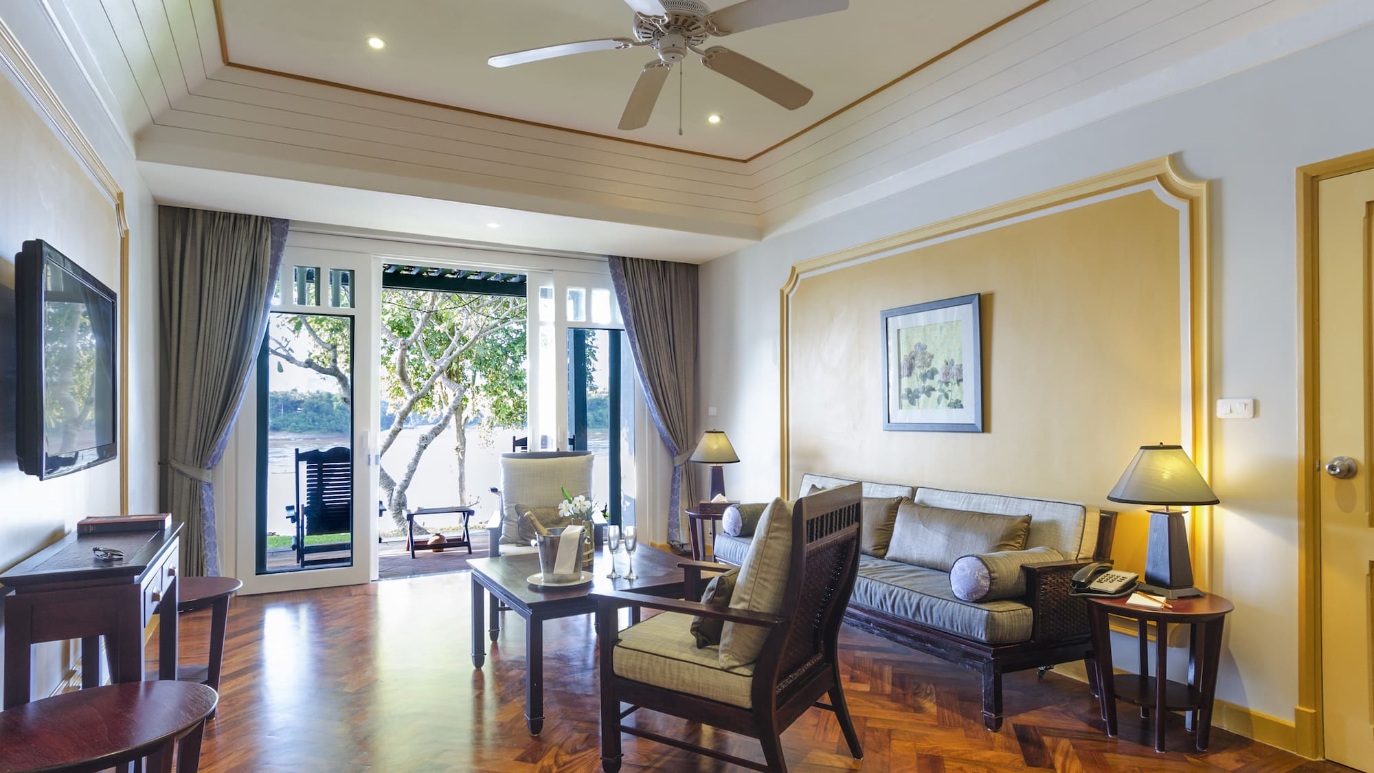 a living room with a ceiling fan and couches