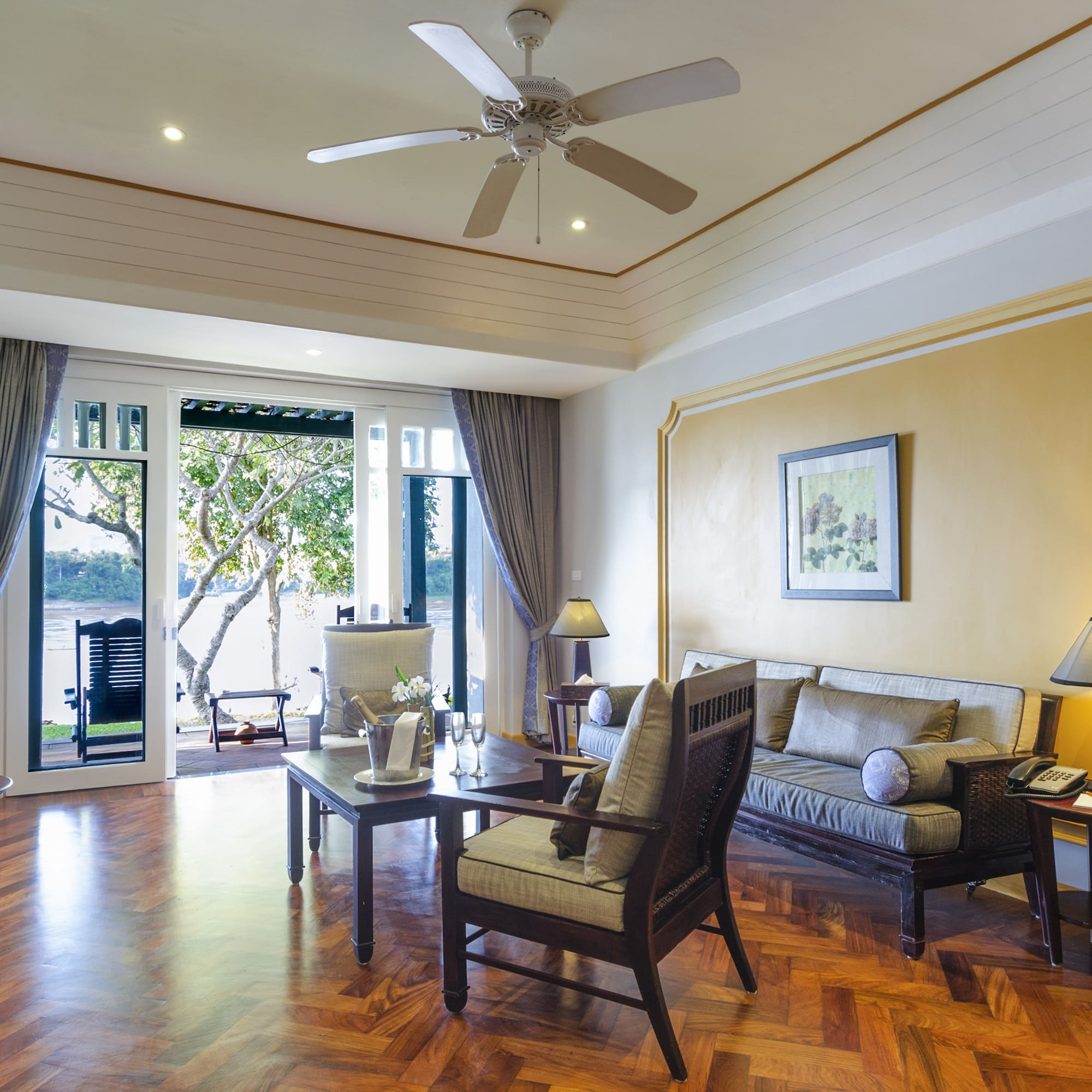 a living room with a ceiling fan and couches