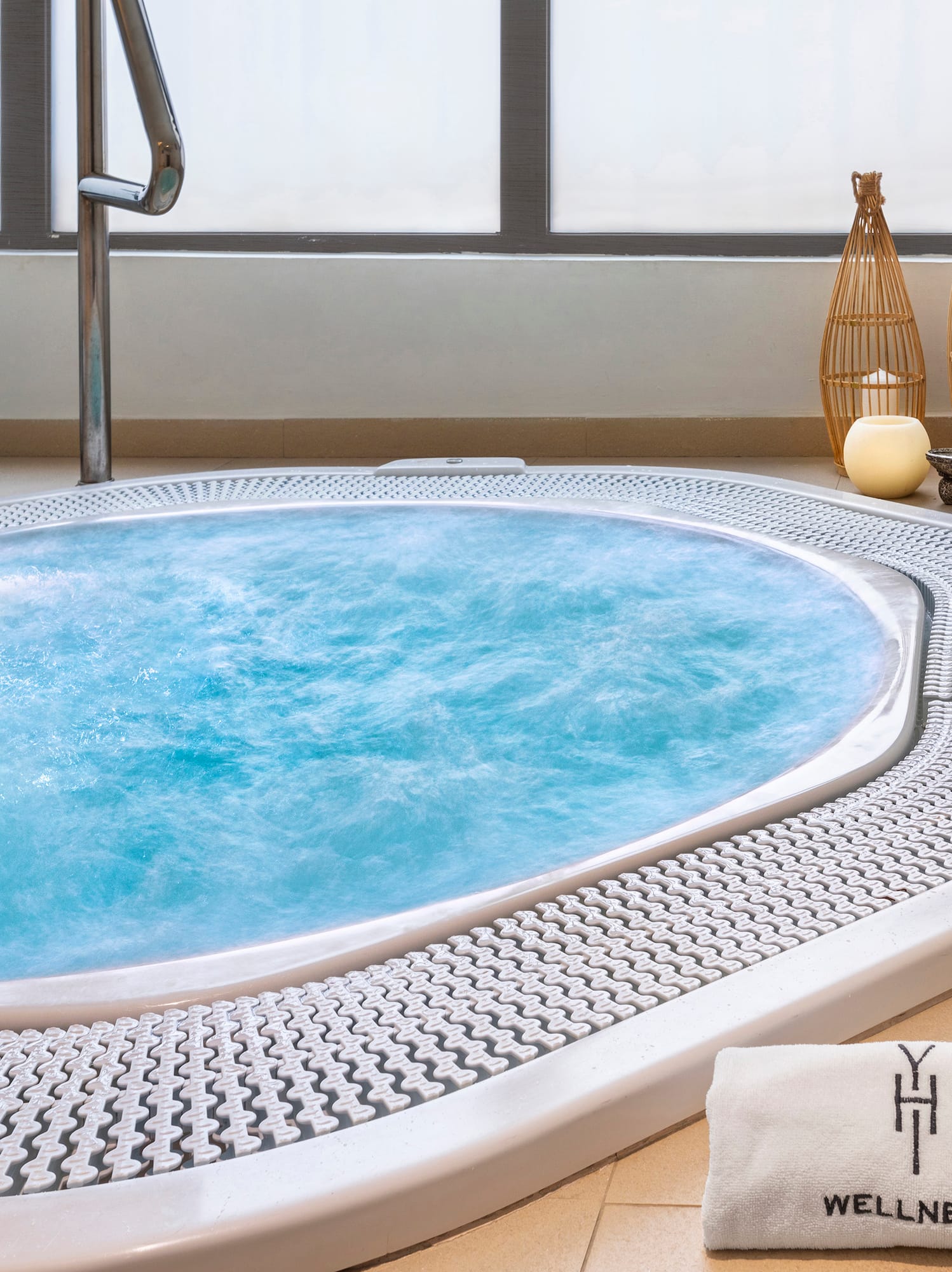 a hot tub with a towel and glasses of wine