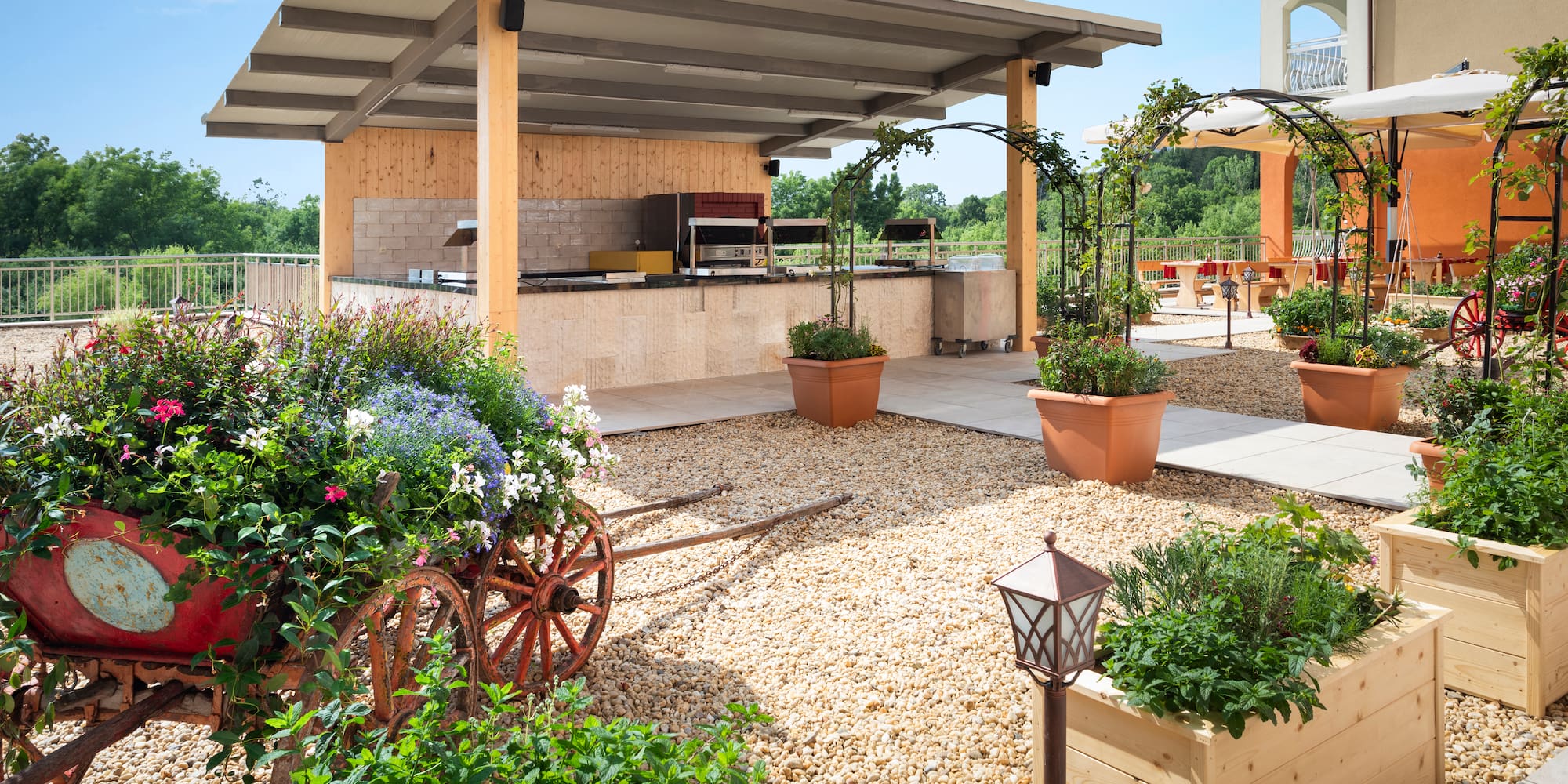 a patio with a covered area with plants and a roof