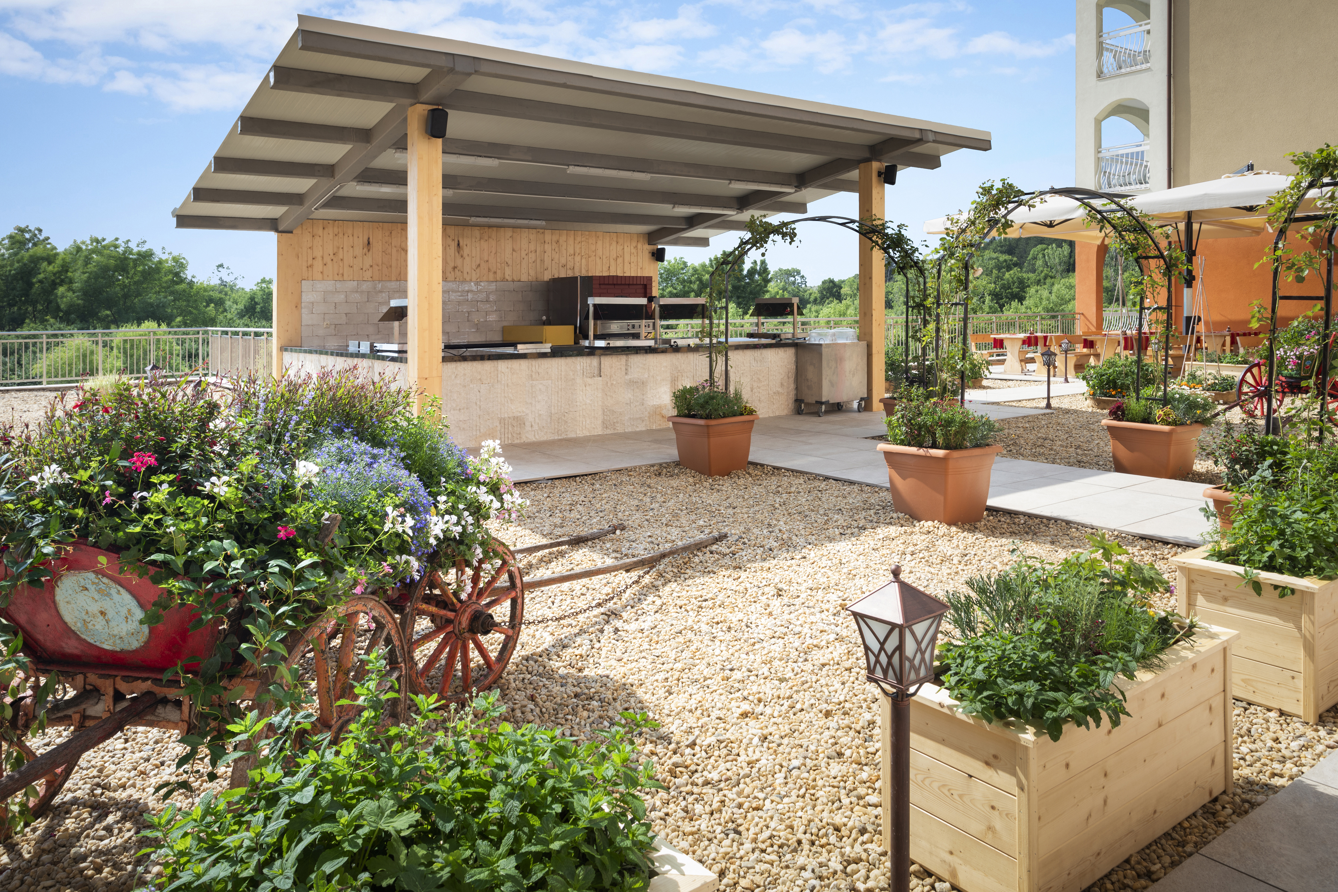 a patio with a covered area with plants and a roof