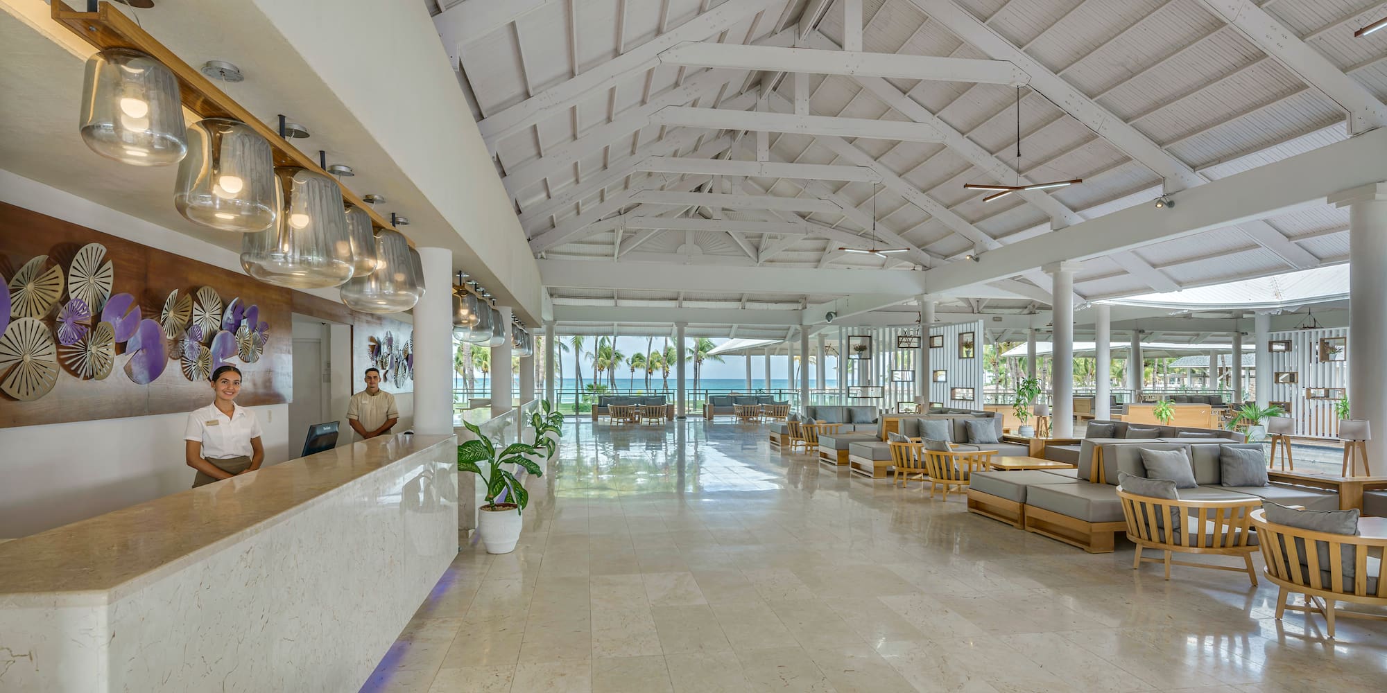 a man standing at a reception desk in a hotel