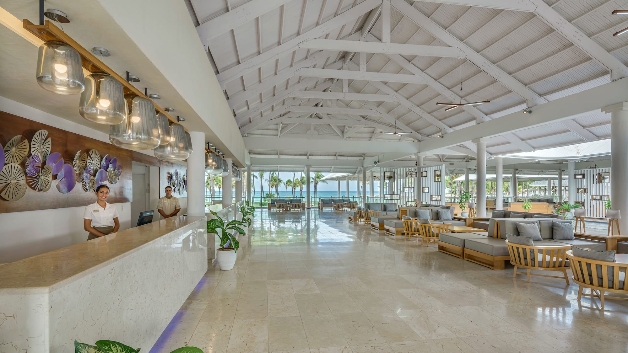 a man standing at a reception desk in a hotel