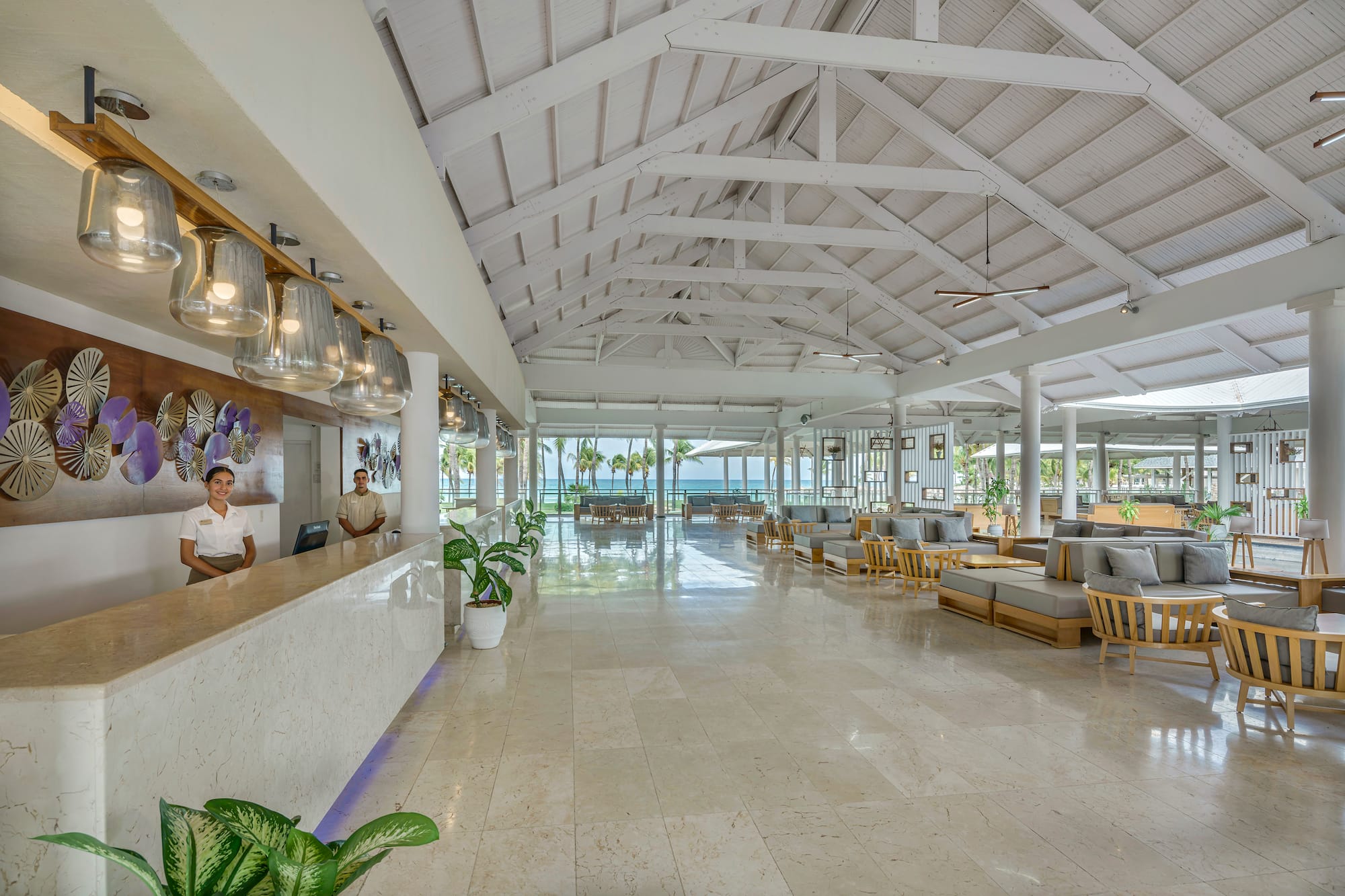 a man standing at a reception desk in a hotel