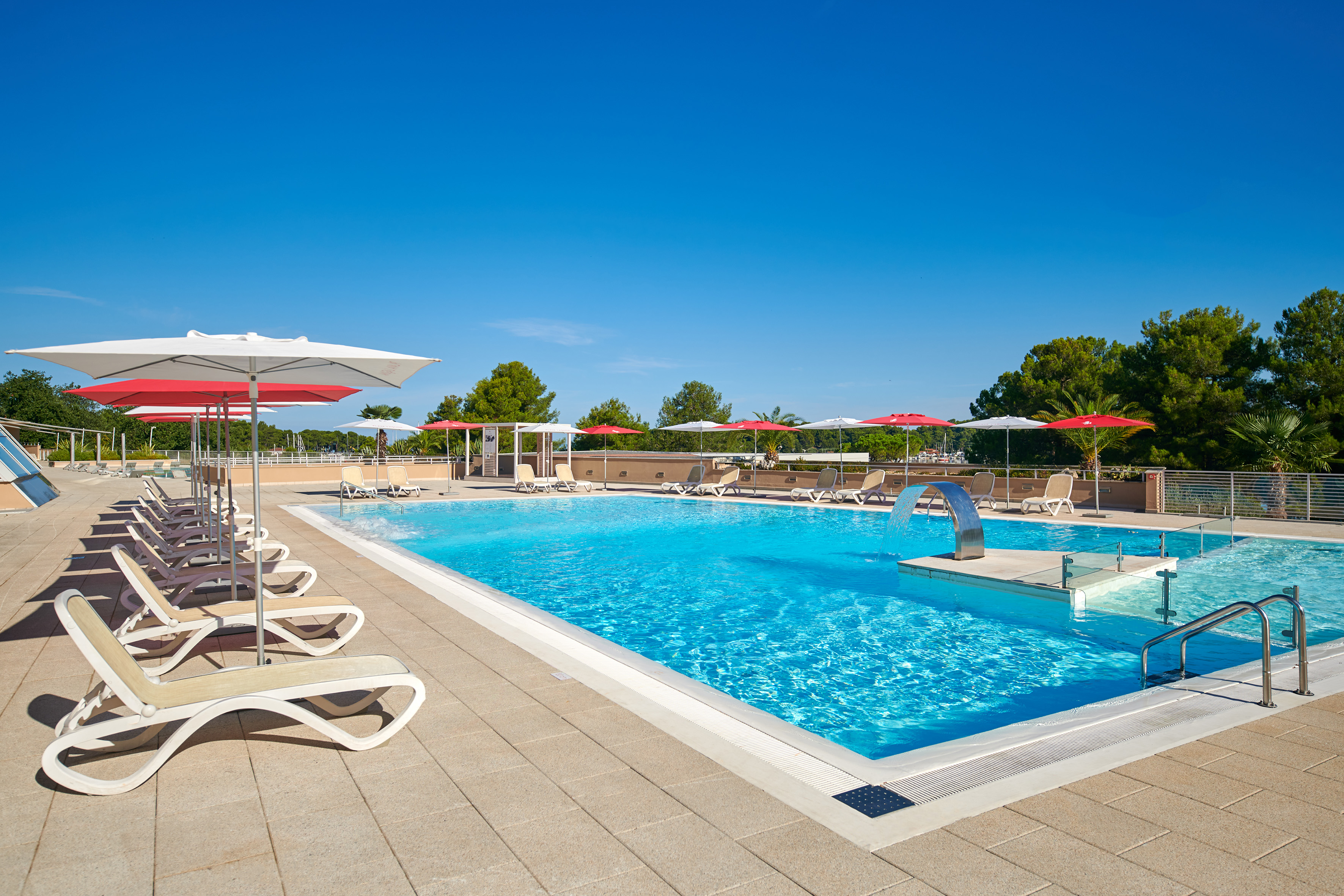 a pool with umbrellas and chairs