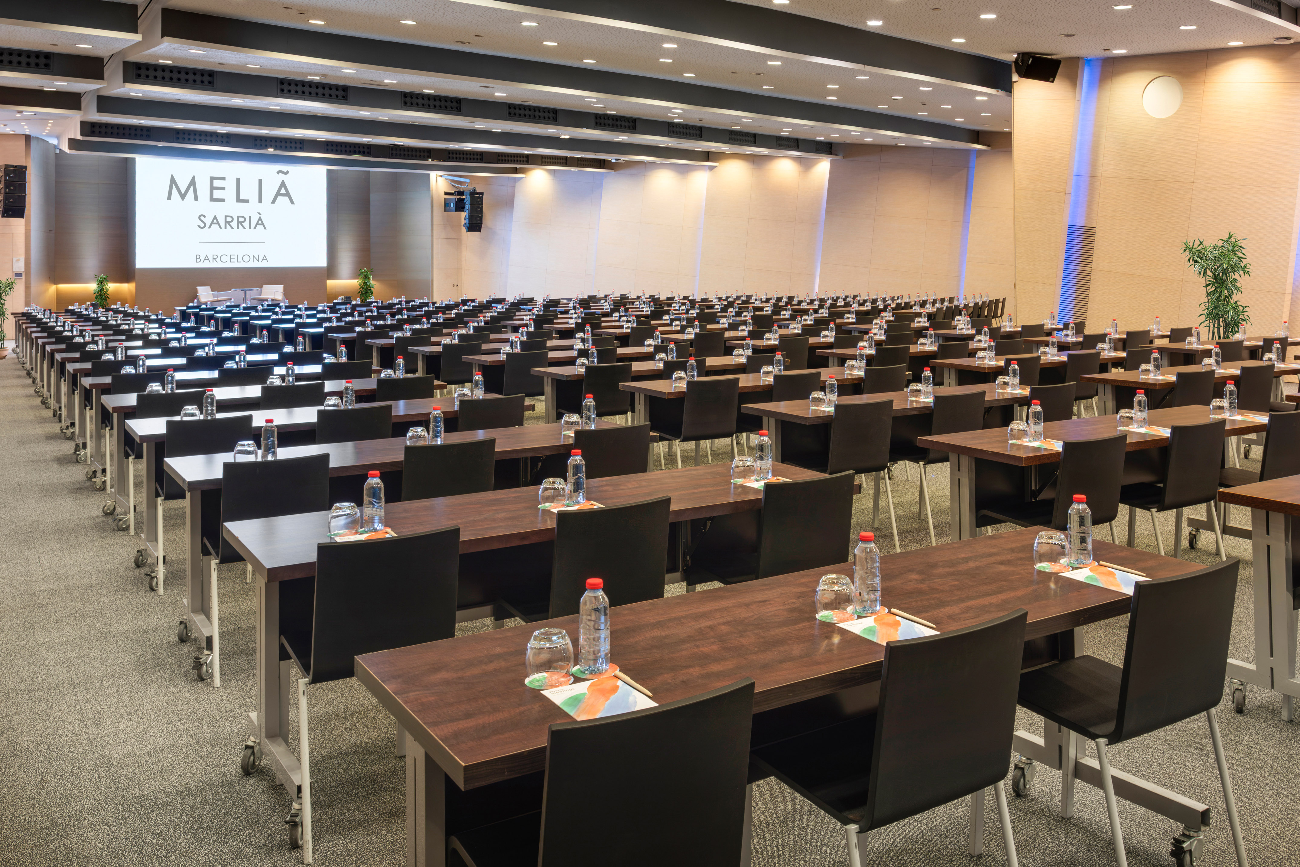 Meliá Sarrià Barcelona conference room with tables, chairs, and a large screen.