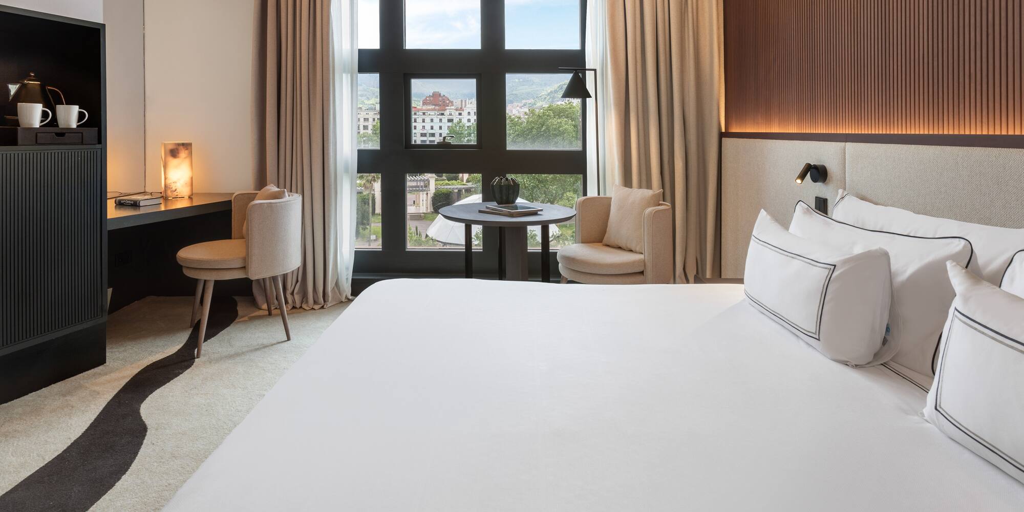 a room with a bed and a table and chairs