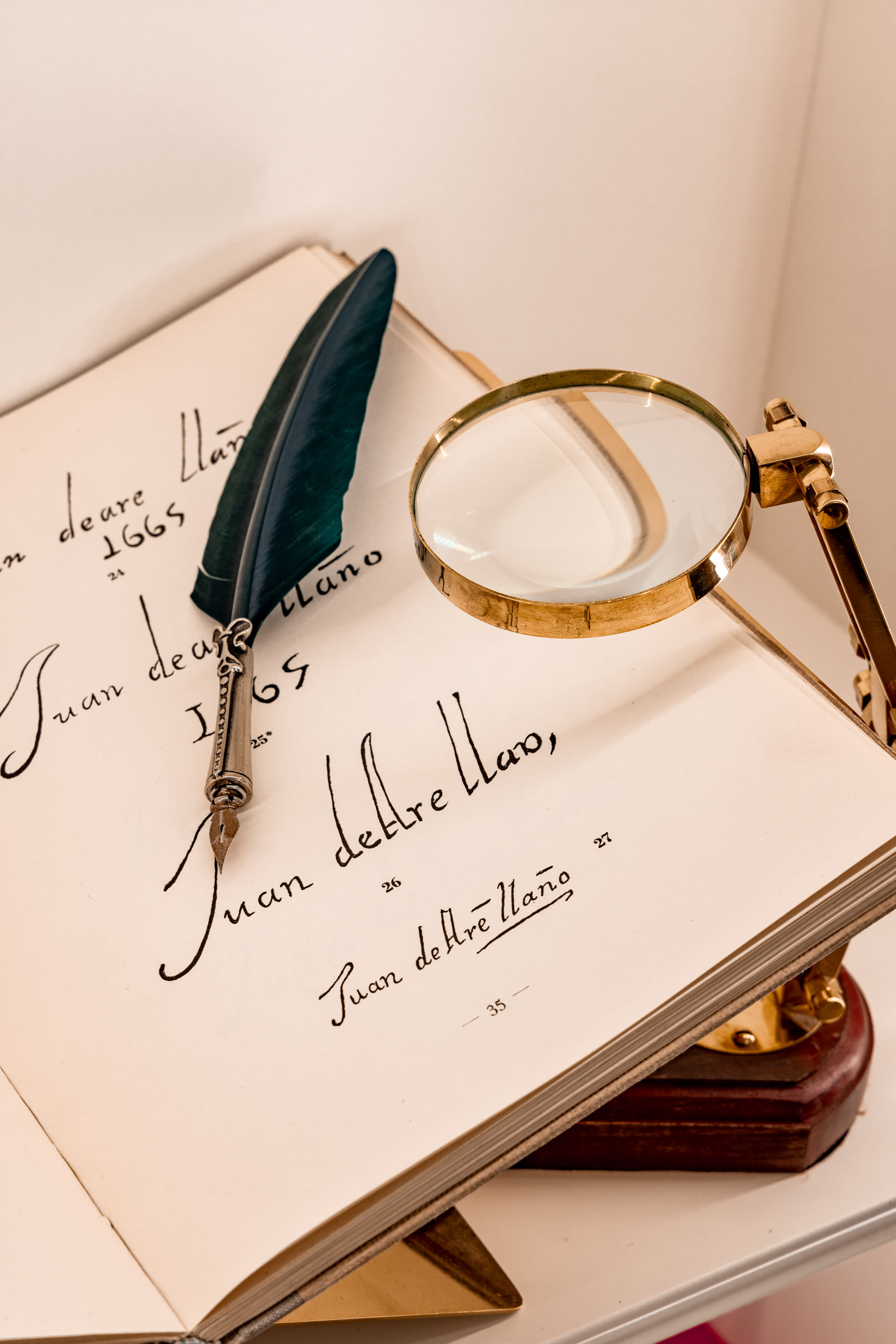 Vintage open book with quill pen, magnifying glass, and old script.