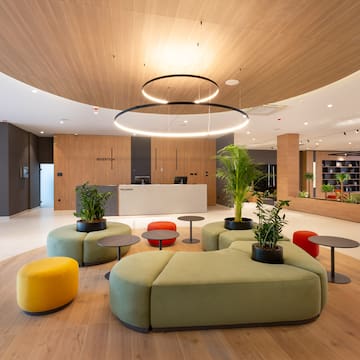 a lobby with a large round table and chairs