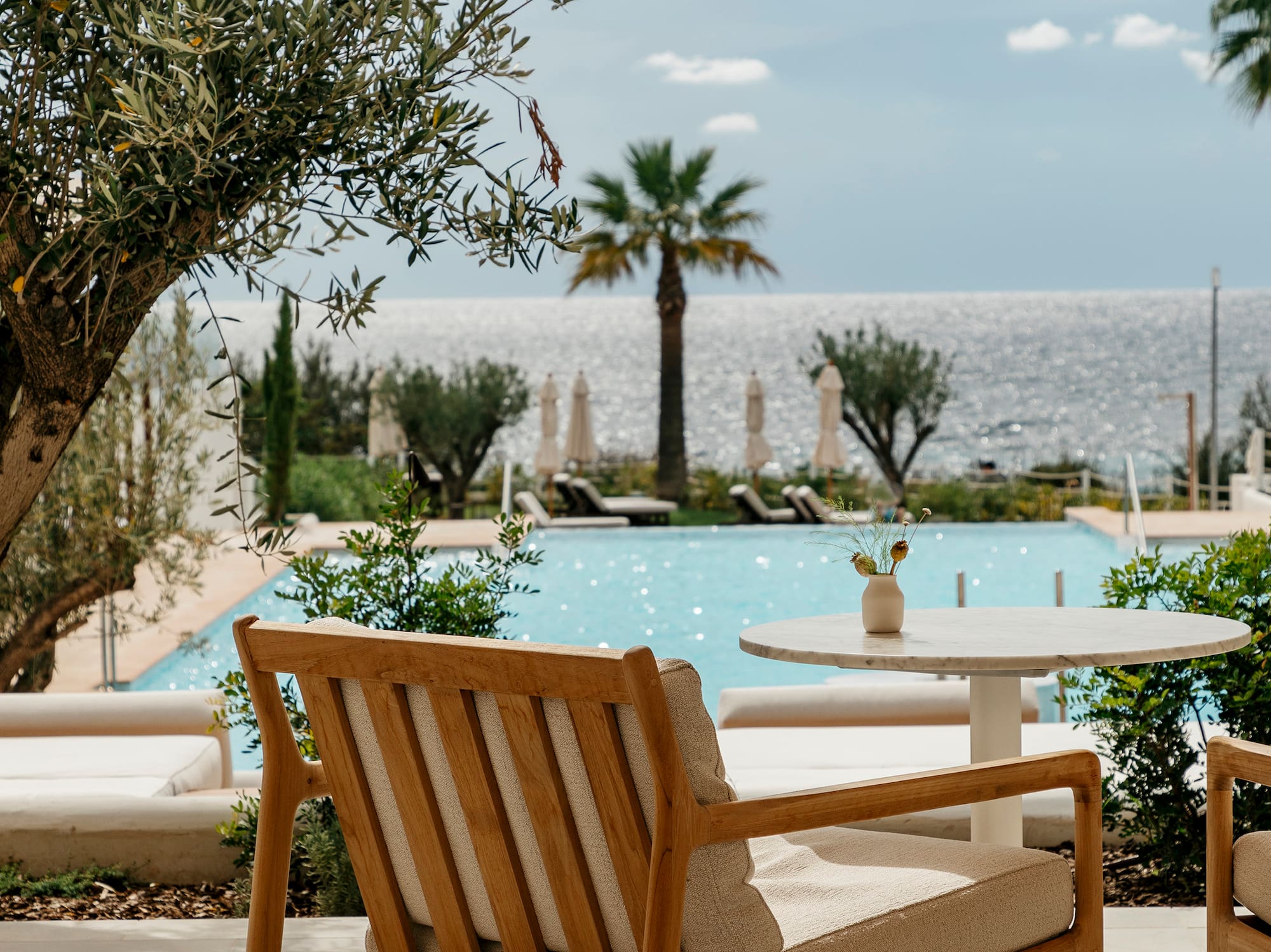 a chair and table with a pool in the background