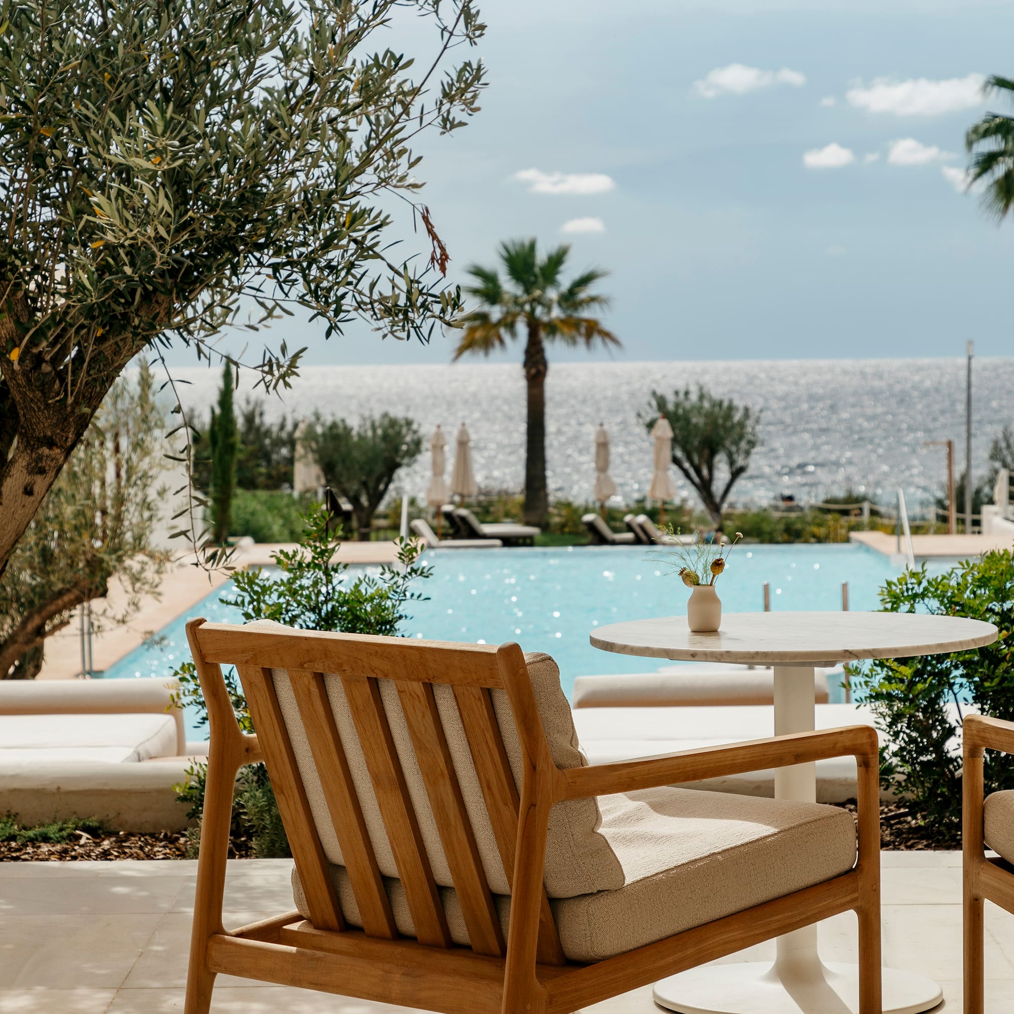 a chair and table with a pool in the background
