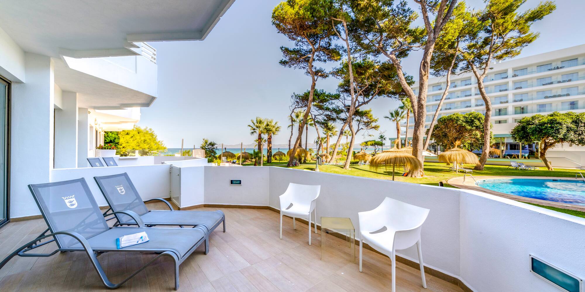 a deck with chairs and a pool in the background