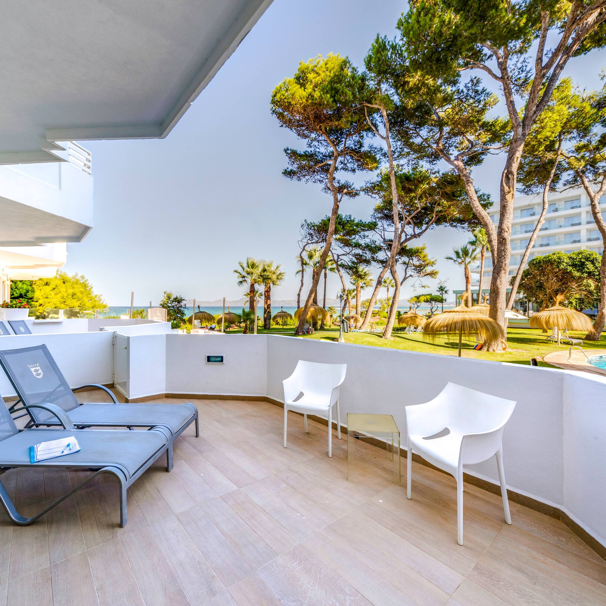 a deck with chairs and a pool in the background
