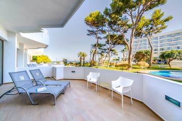 a deck with chairs and a pool in the background
