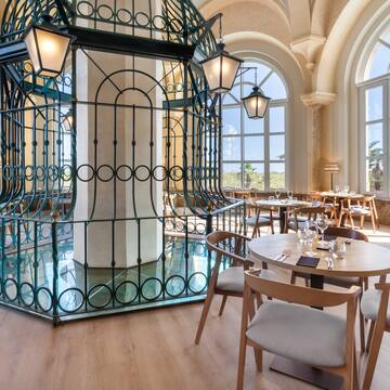 a room with tables and chairs and a metal cage