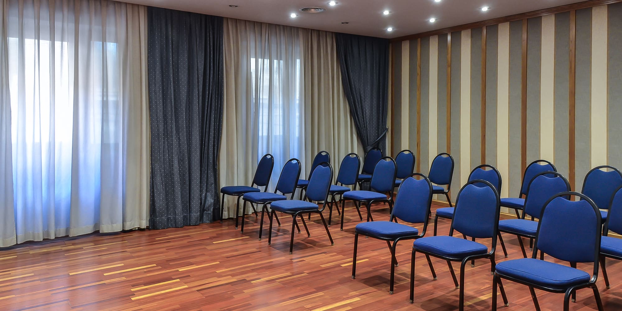 a room with blue chairs and a wood floor