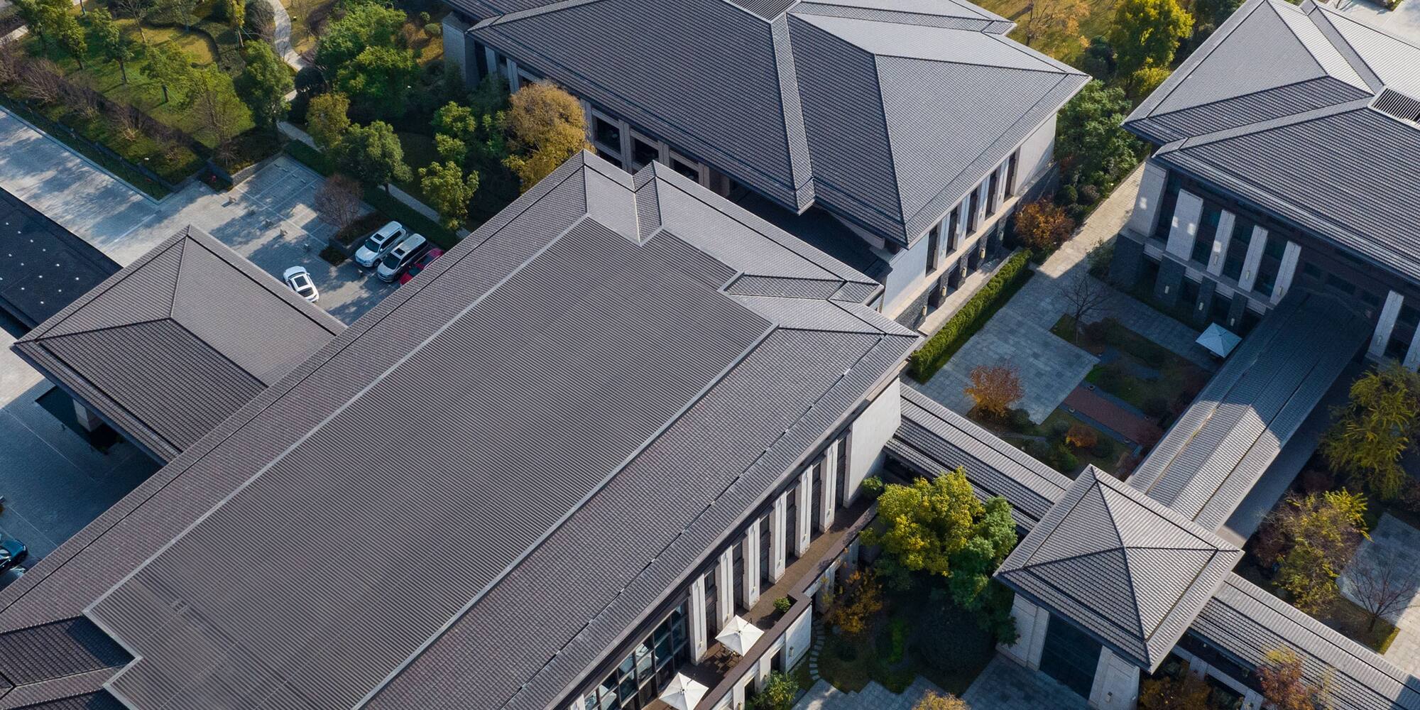 a group of buildings with trees and a river