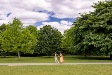 a man and woman walking on a path in a park