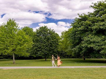 a man and woman walking on a path in a park