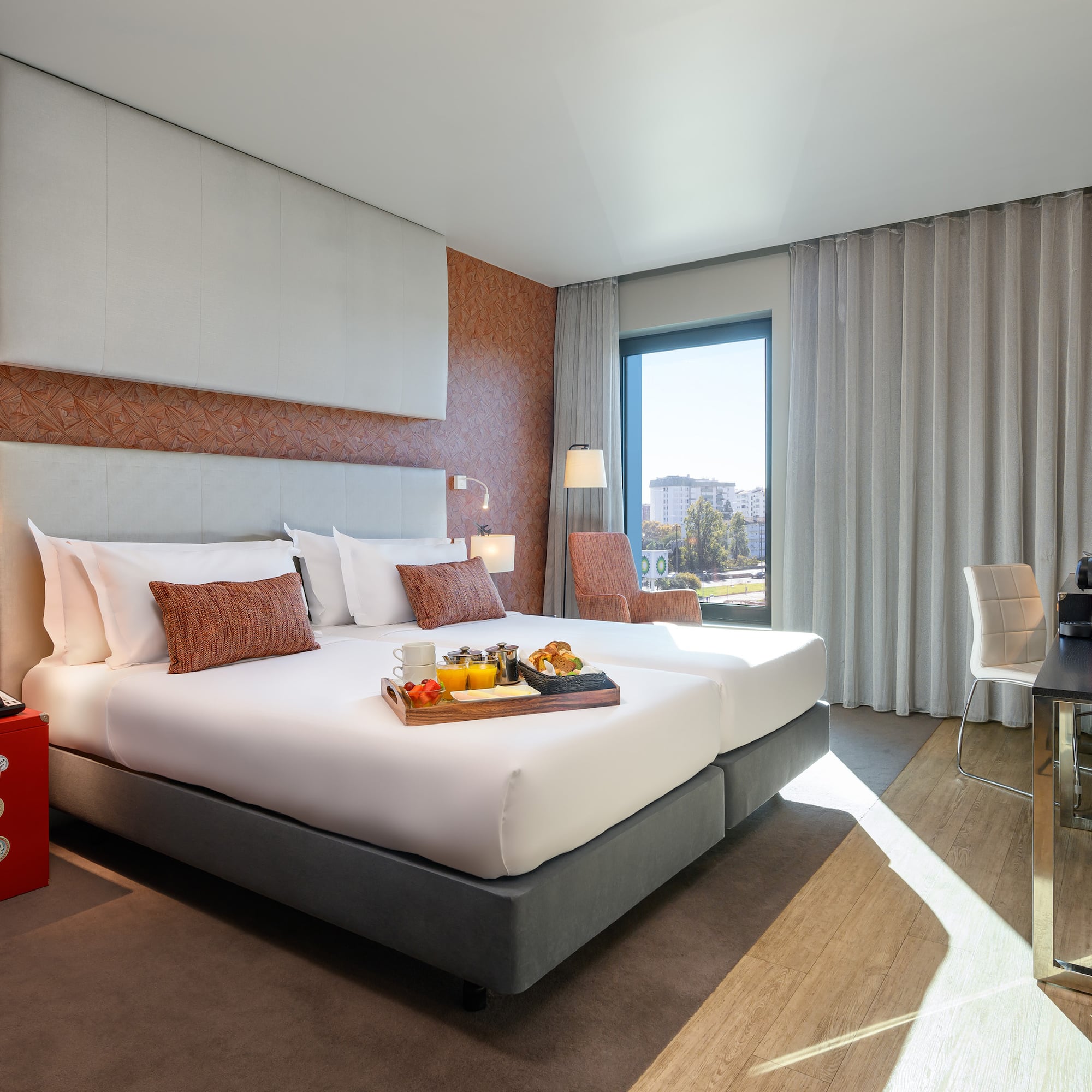 a hotel room with a tray of food on a bed