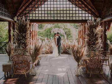 a man and woman kissing under a gazebo