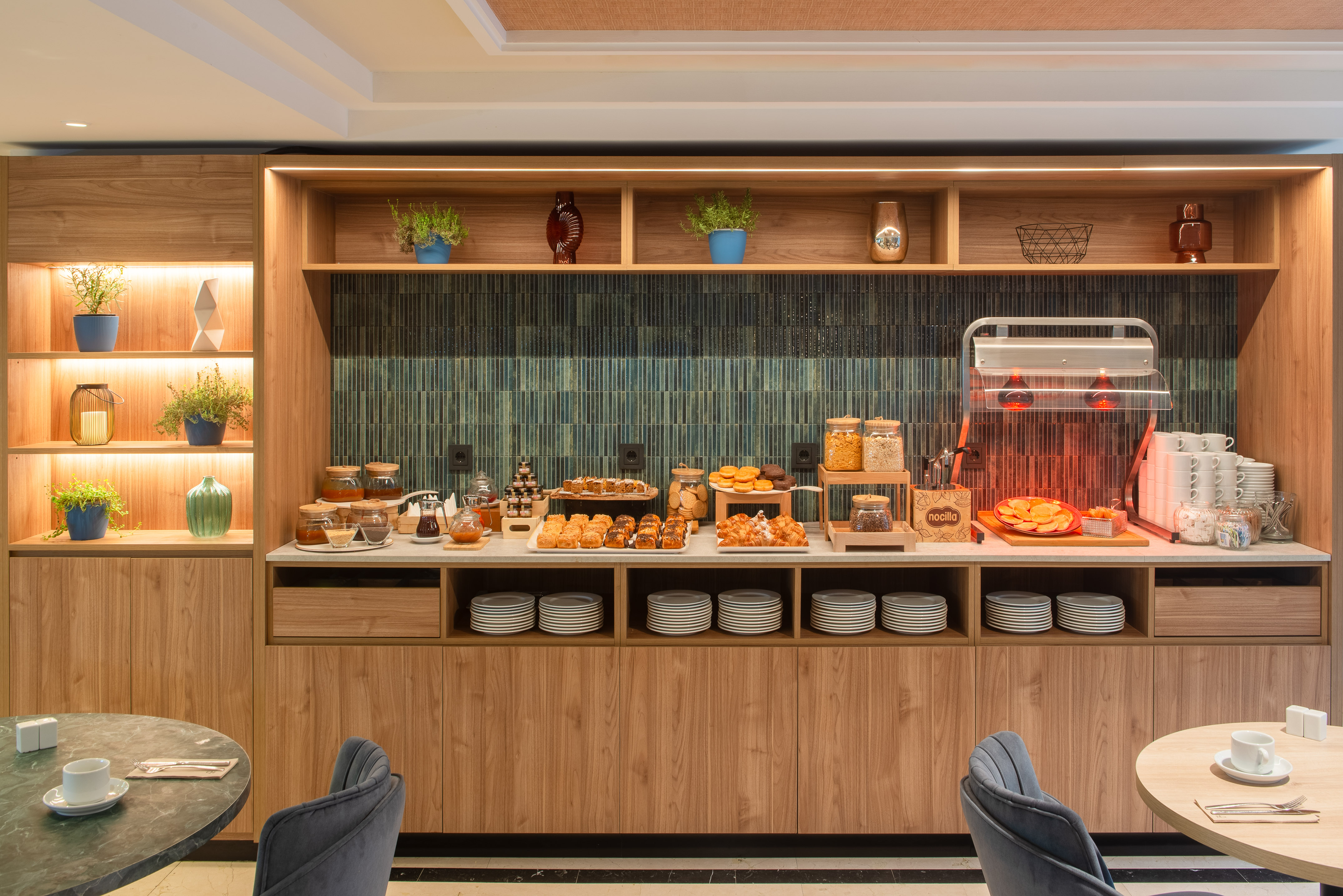 Hotel breakfast buffet with assorted pastries, cereals, jams, and hot items.