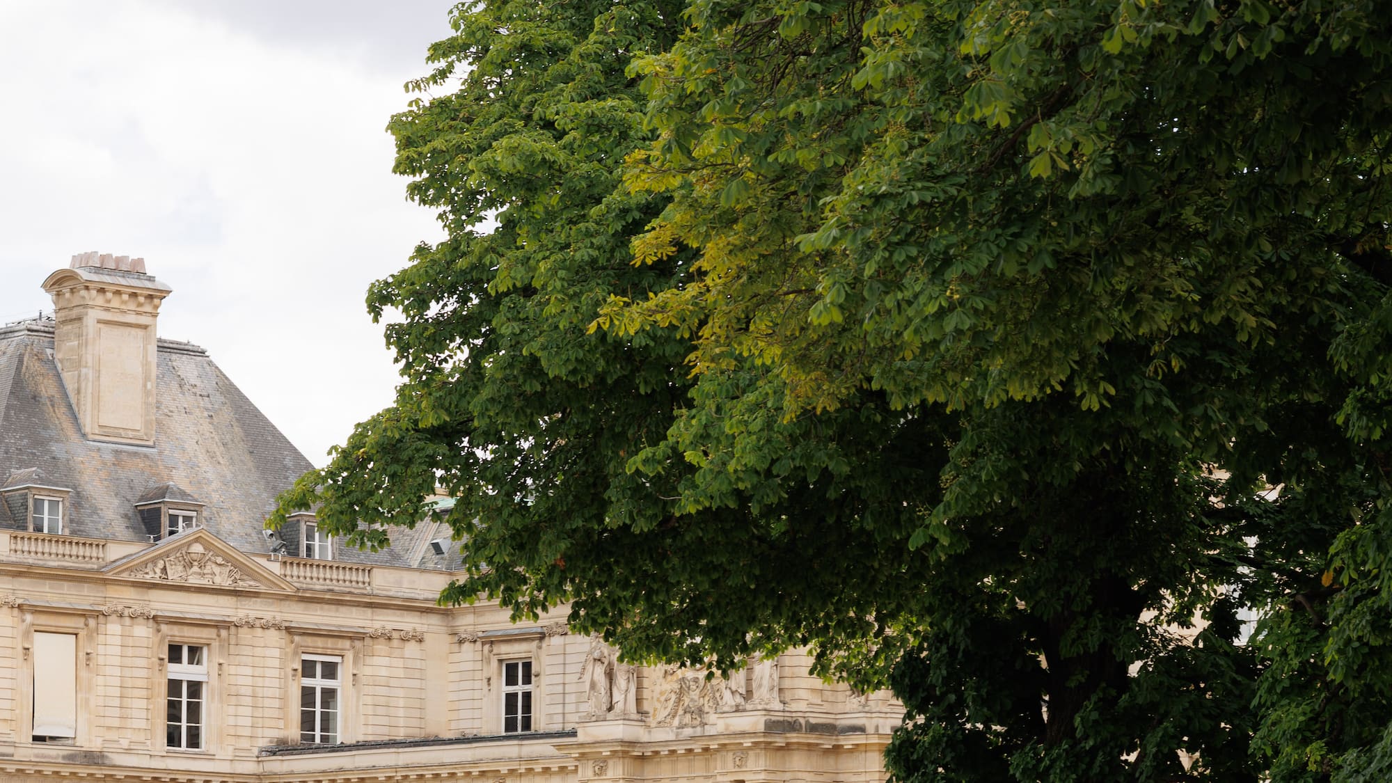 a woman sitting in a chair in front of a large stone building