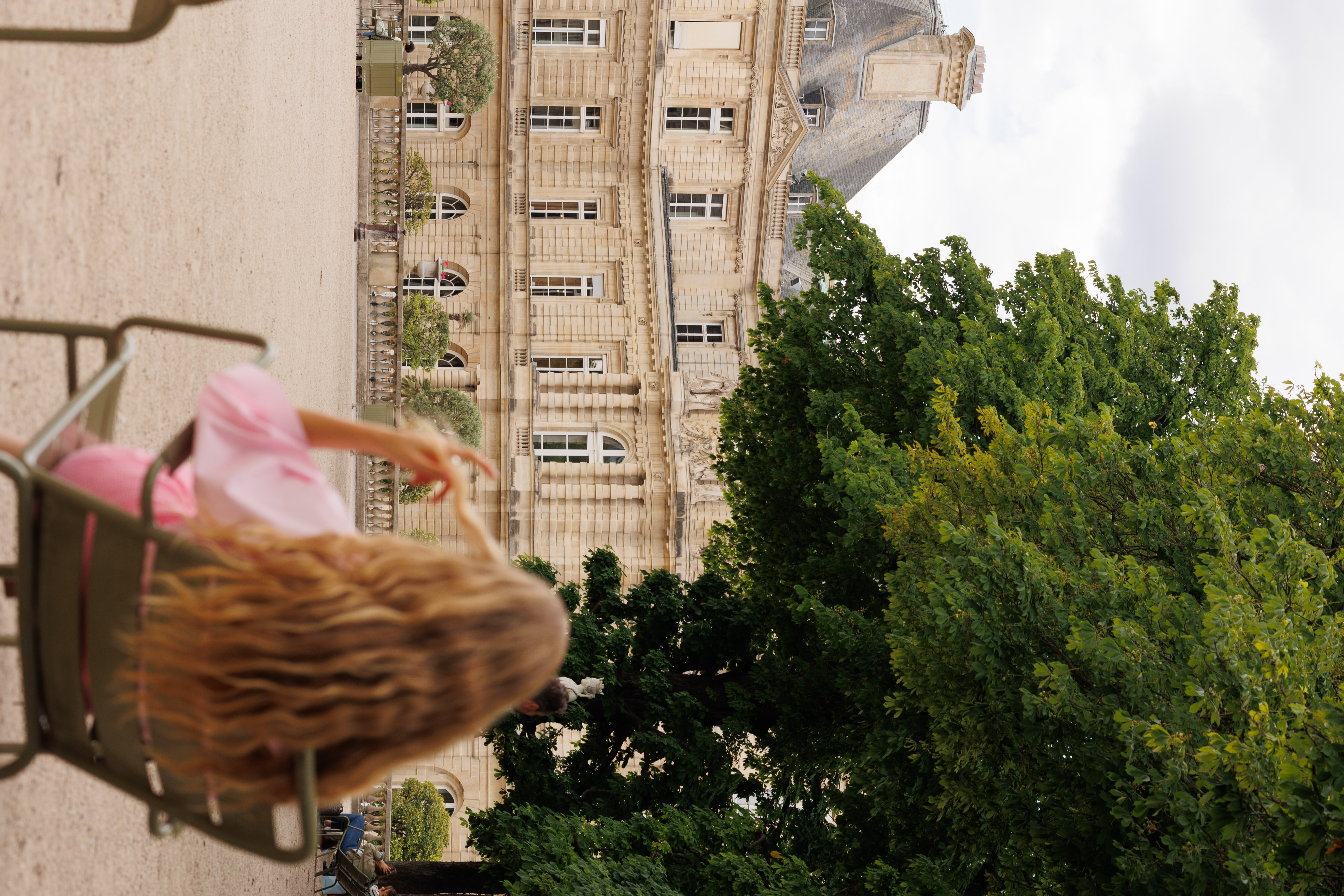 a woman sitting in a chair in front of a large building