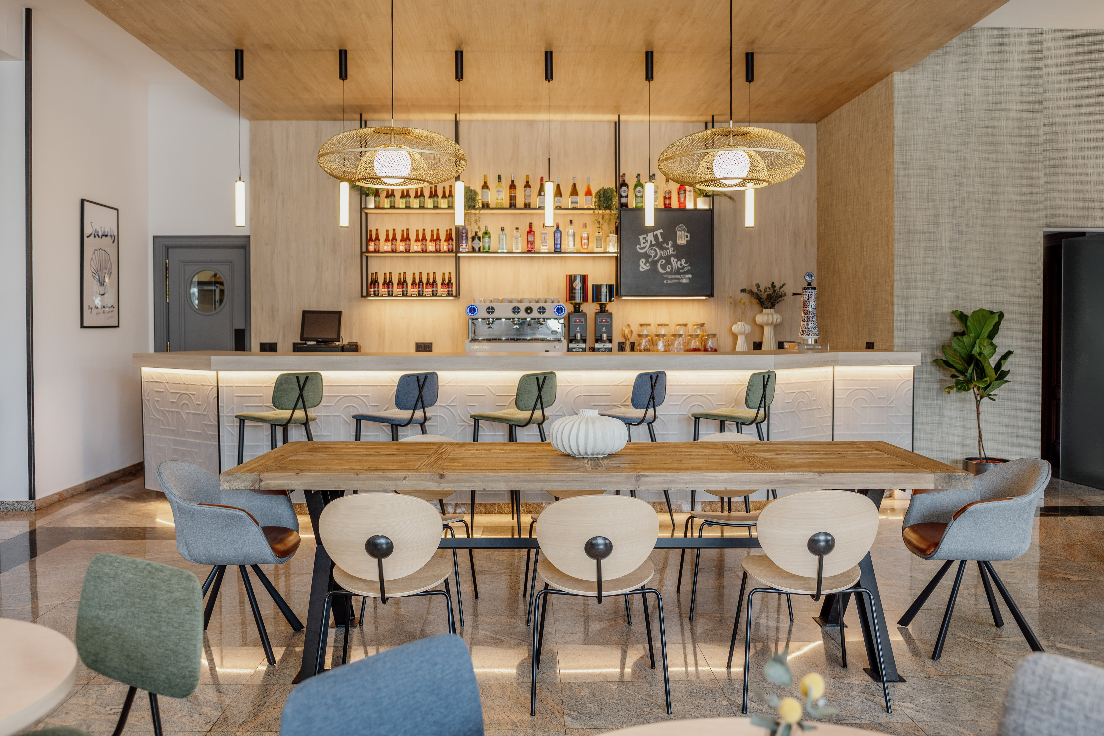 Modern cafe bar with stylish lounge, wooden table, and illuminated counter.