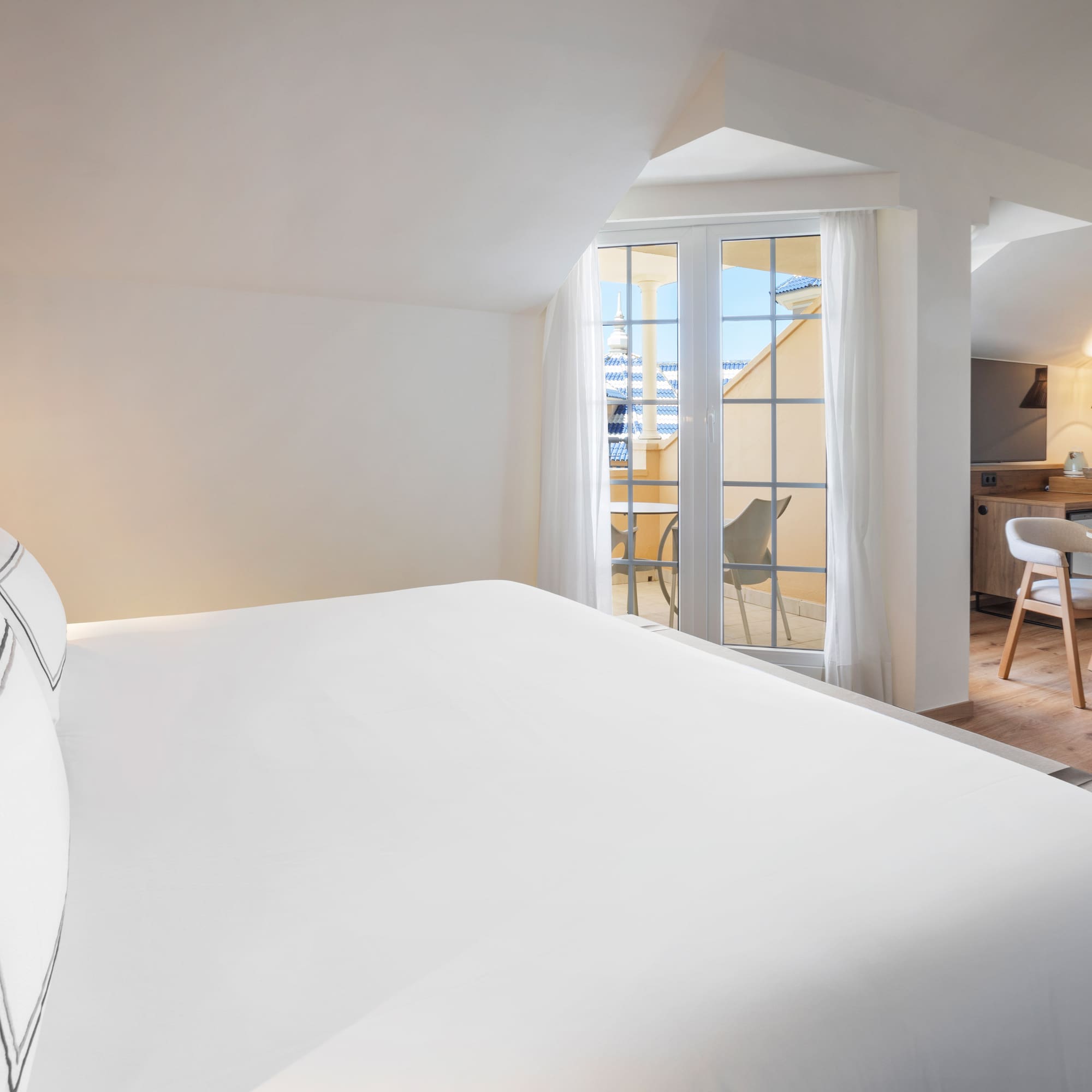 a bed in a room with a kitchen and dining area