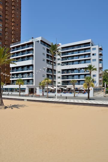 a building with palm trees and a beach
