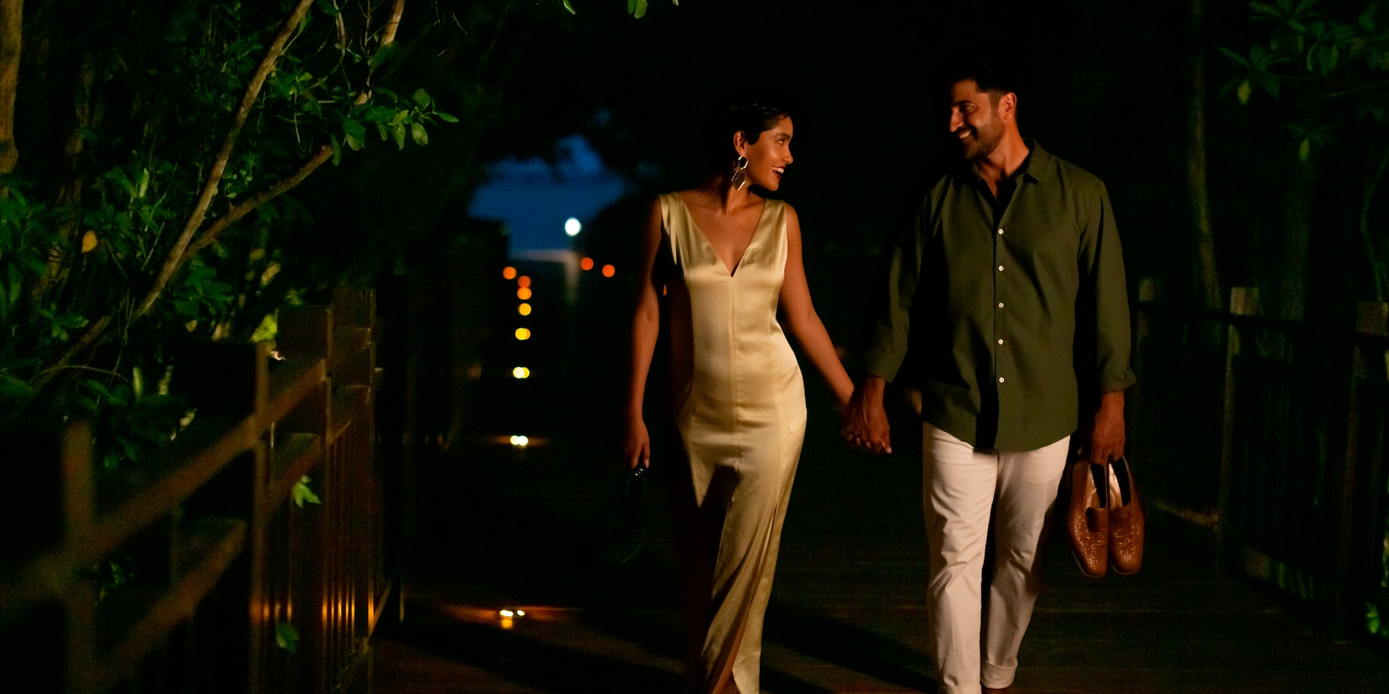 a man and woman walking on a wooden walkway