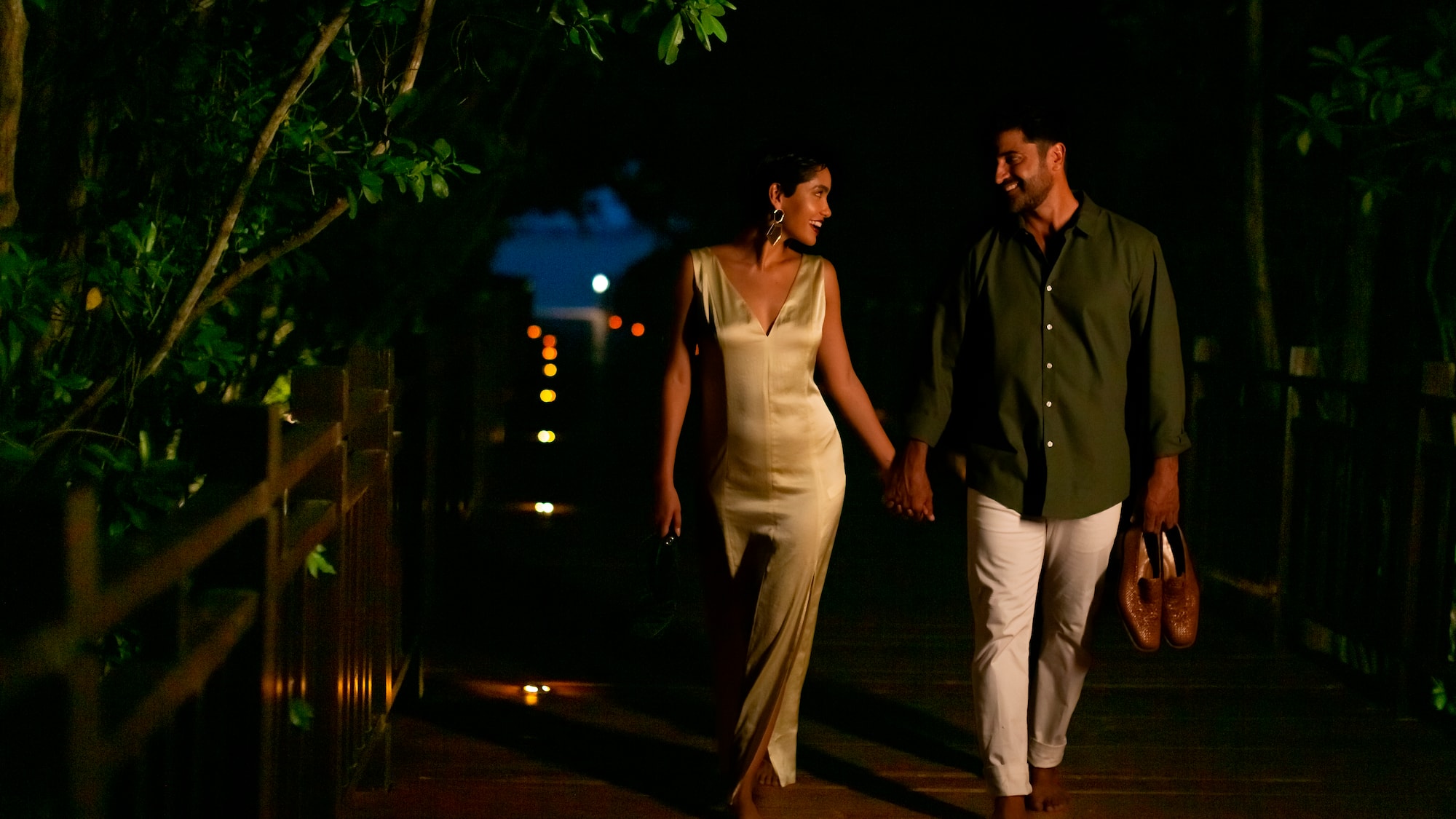 a man and woman walking on a wooden walkway