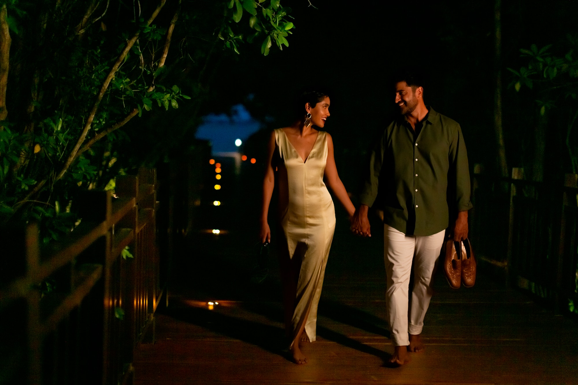 a man and woman walking on a wooden walkway