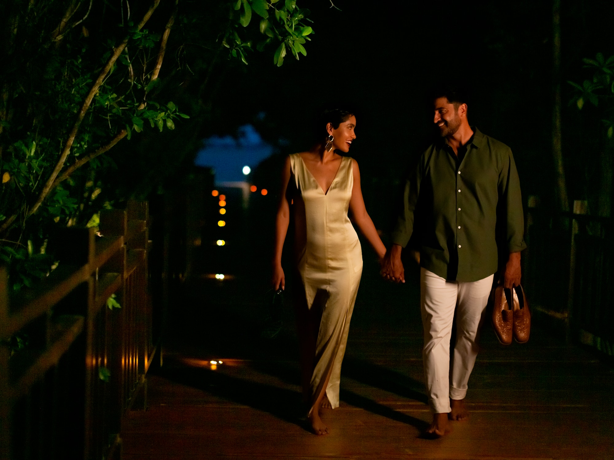 a man and woman walking on a wooden walkway