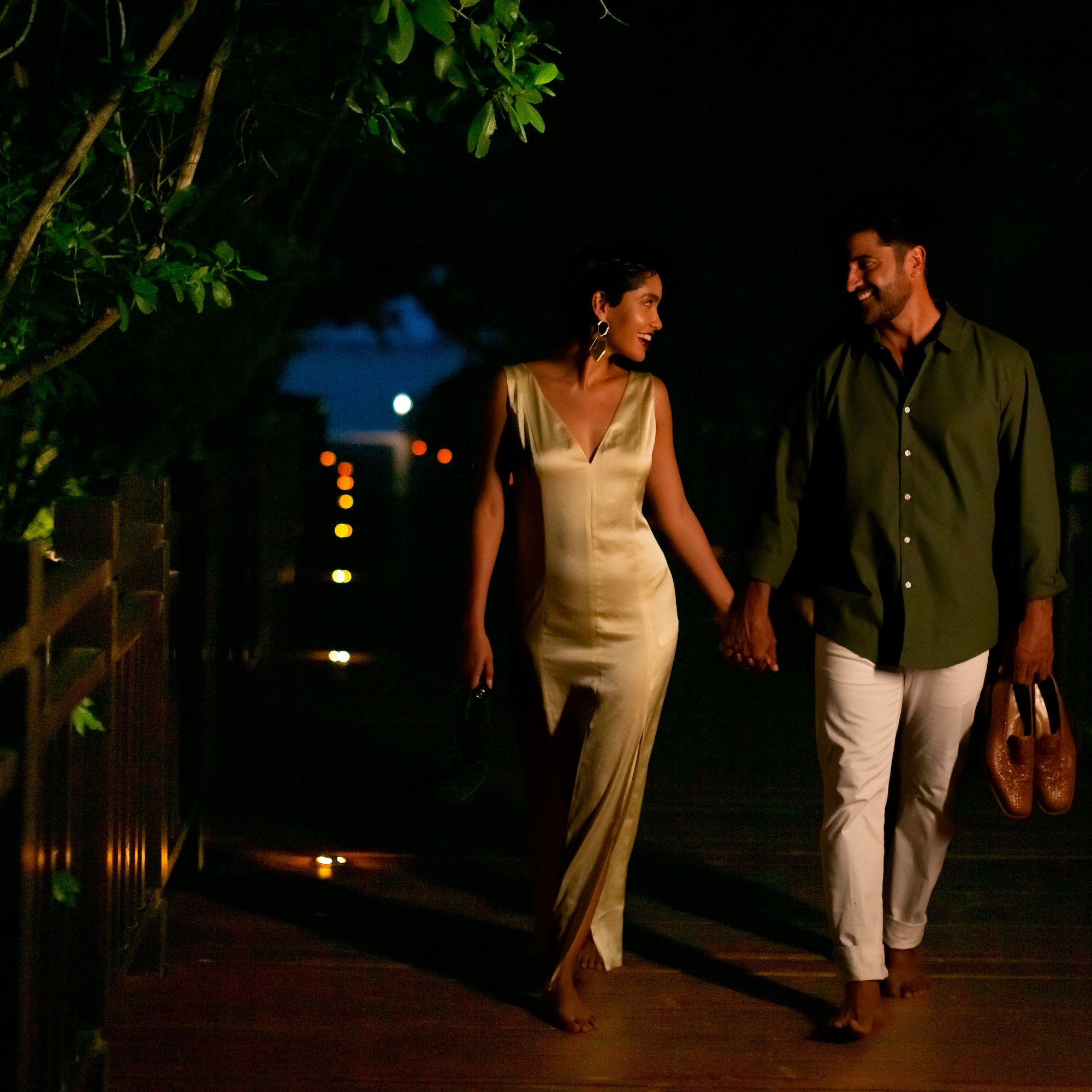 a man and woman walking on a wooden walkway
