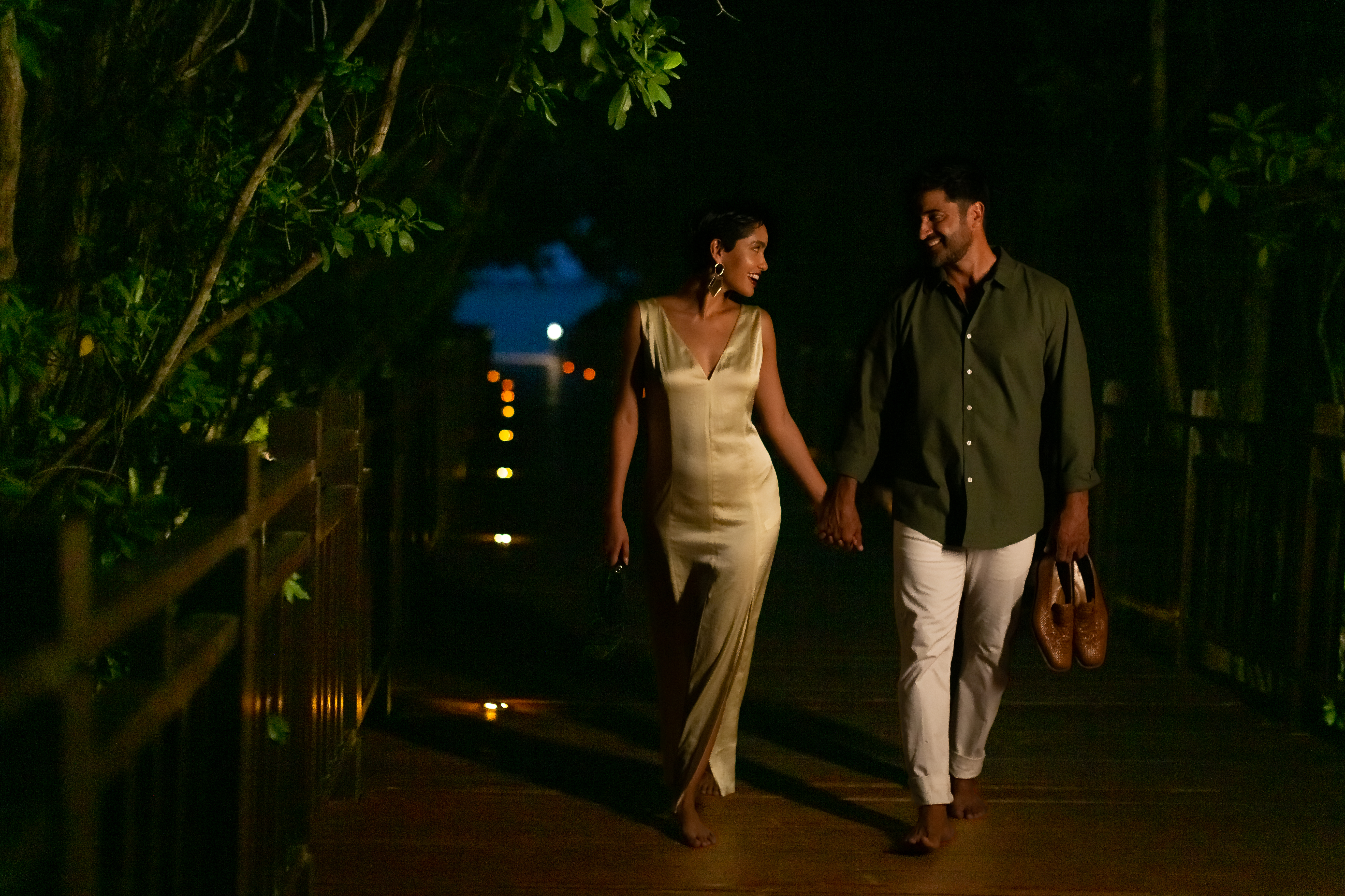 a man and woman walking on a wooden walkway