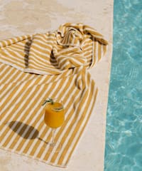 a drink on a towel by a pool