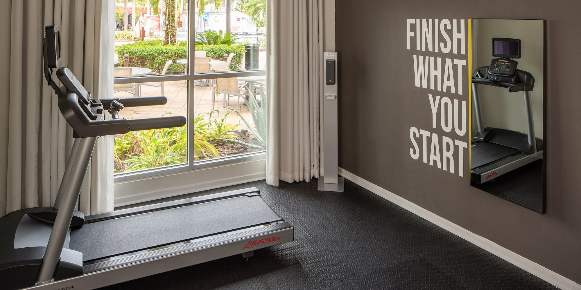 a gym with treadmills and a window