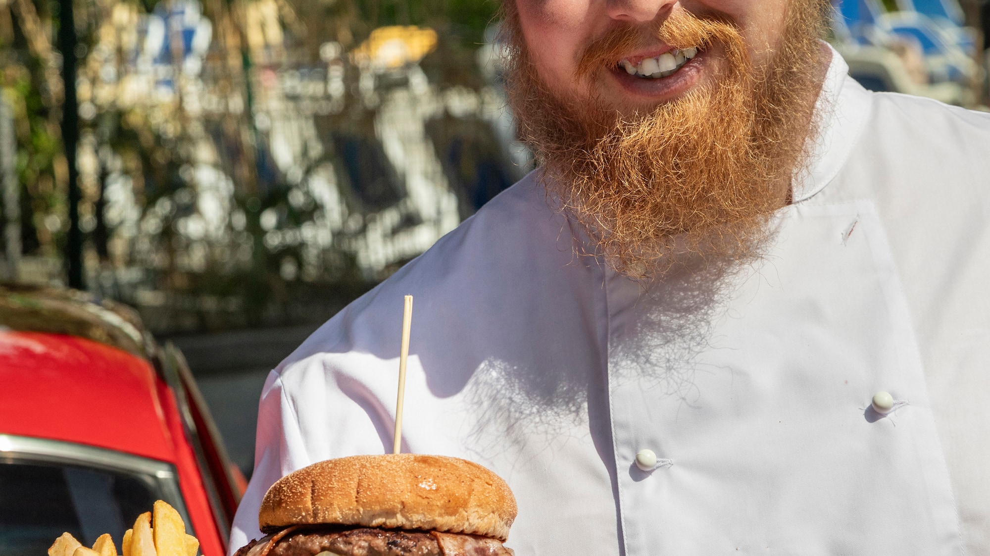 a man wearing a chef's hat and holding a plate of food