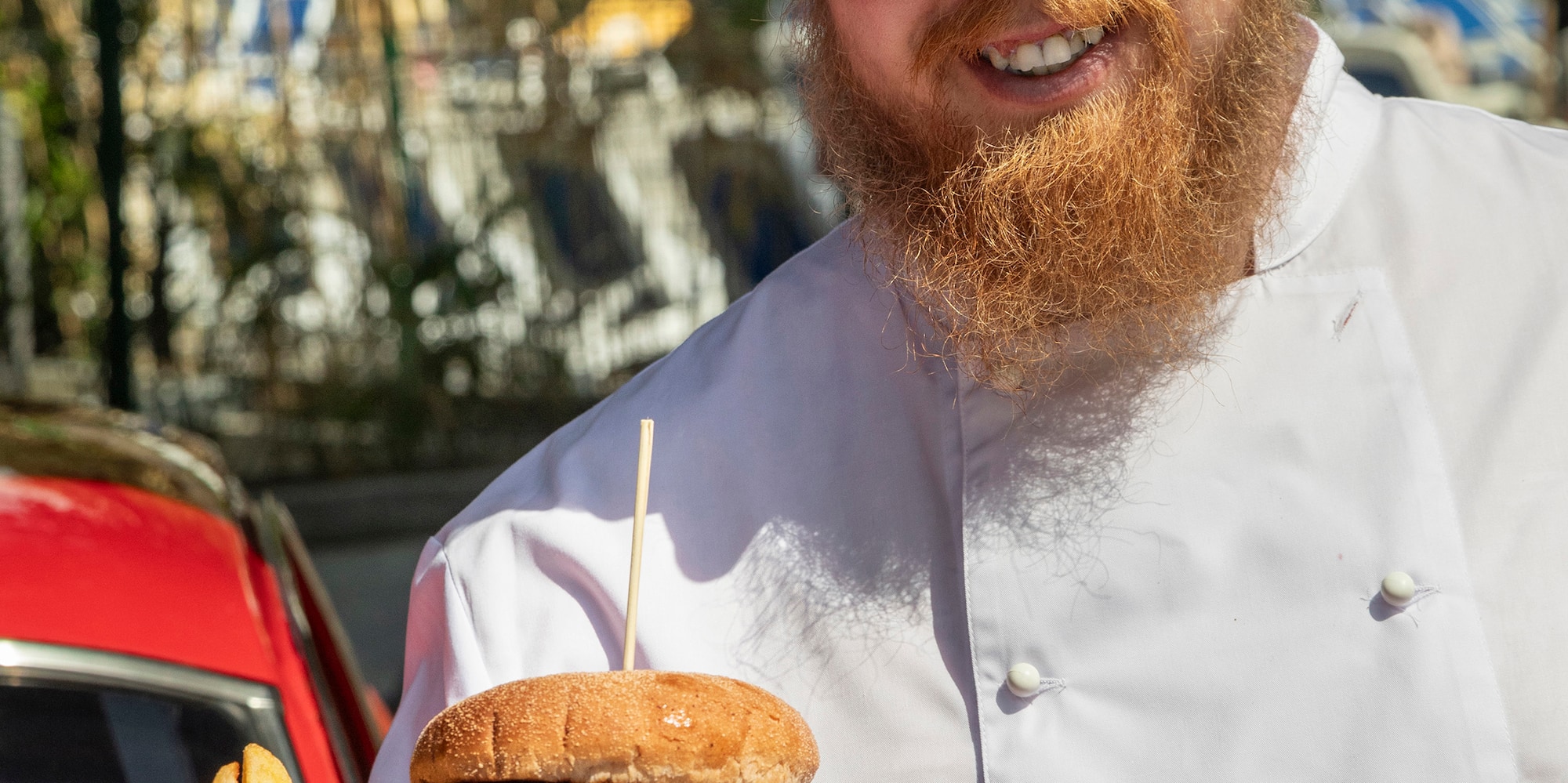 a man wearing a chef's hat and holding a plate of food