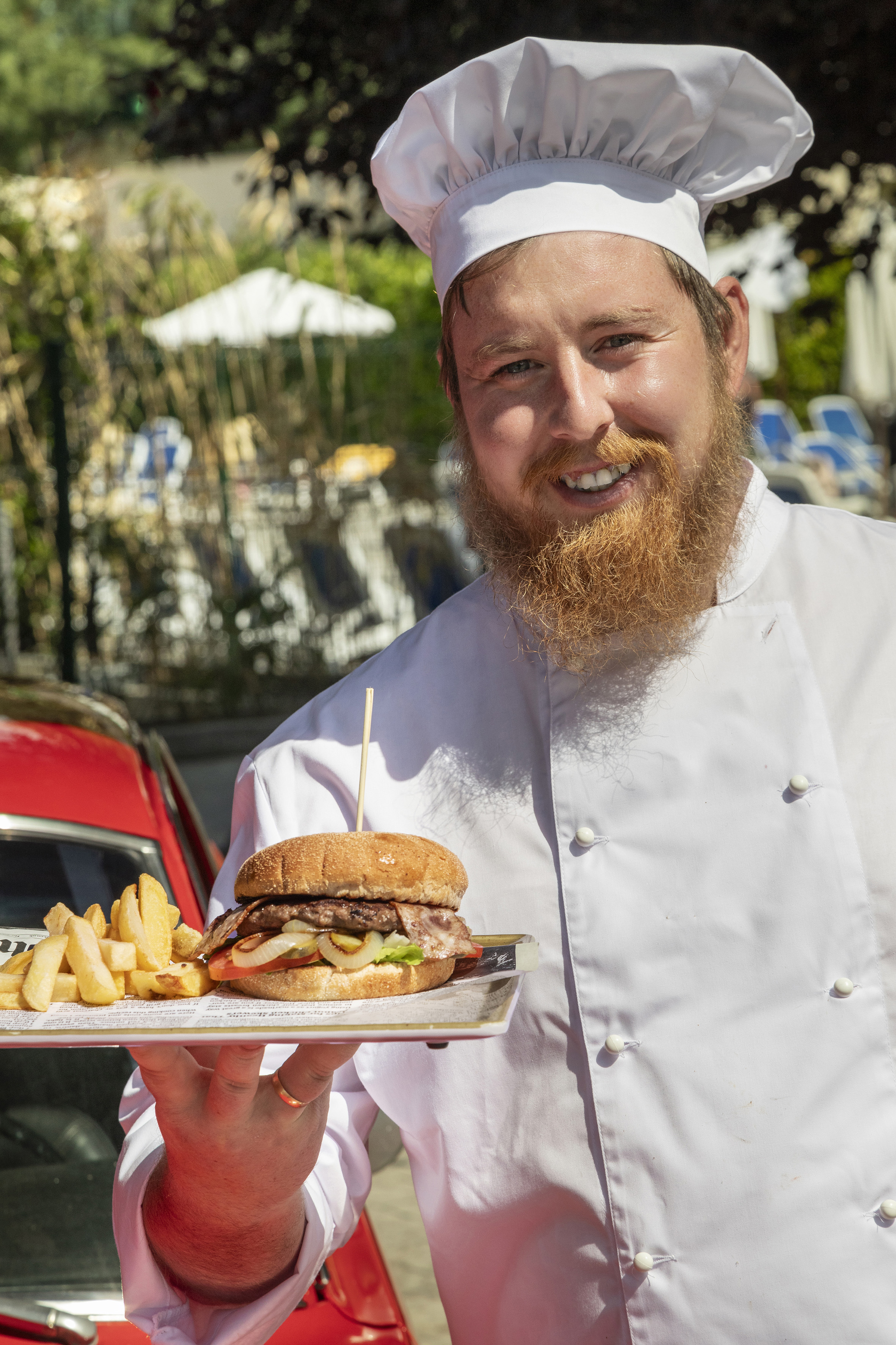 a man wearing a chef's hat and holding a plate of food