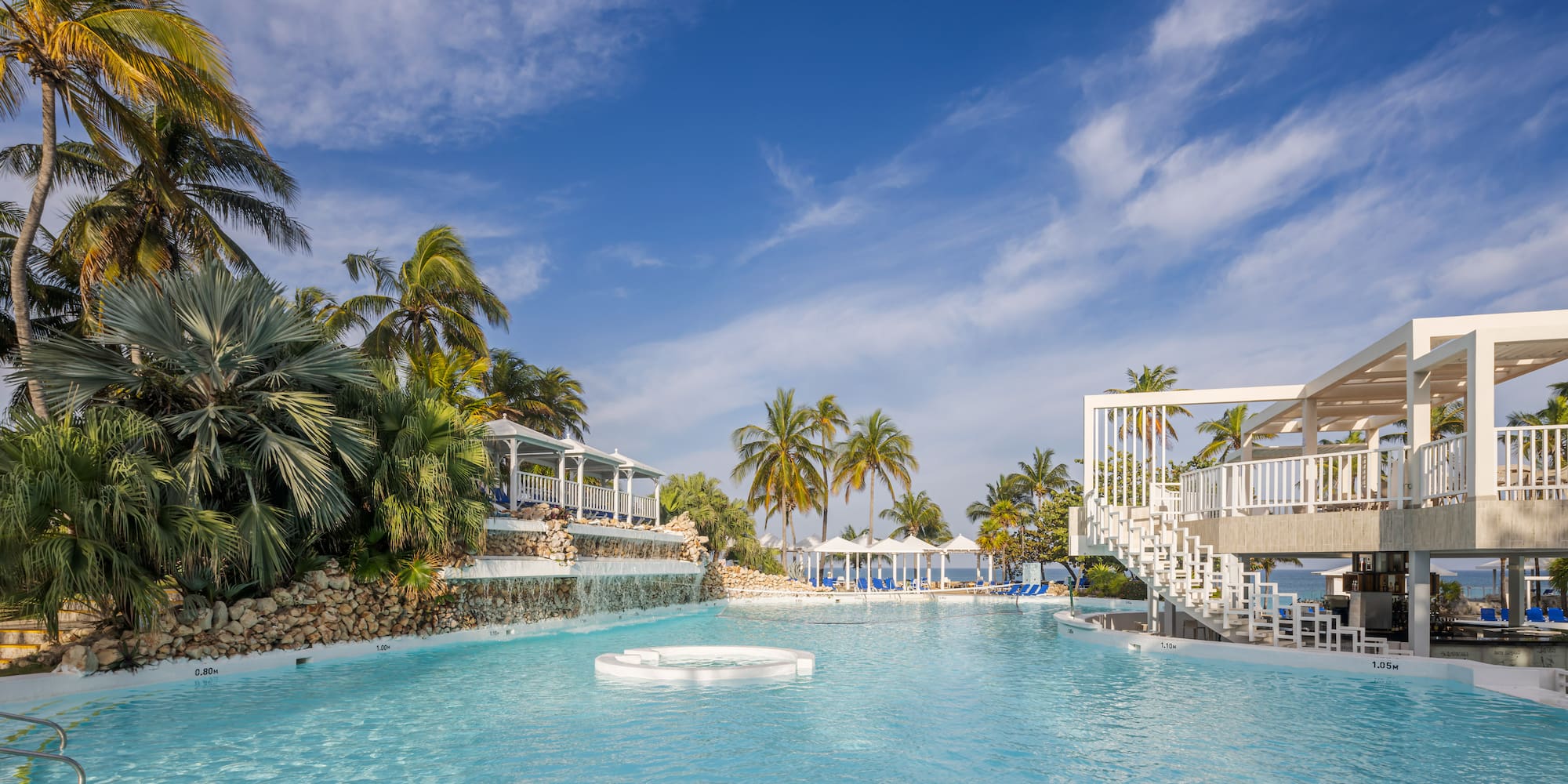 a pool with a waterfall and palm trees