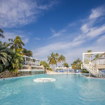 a pool with a waterfall and palm trees