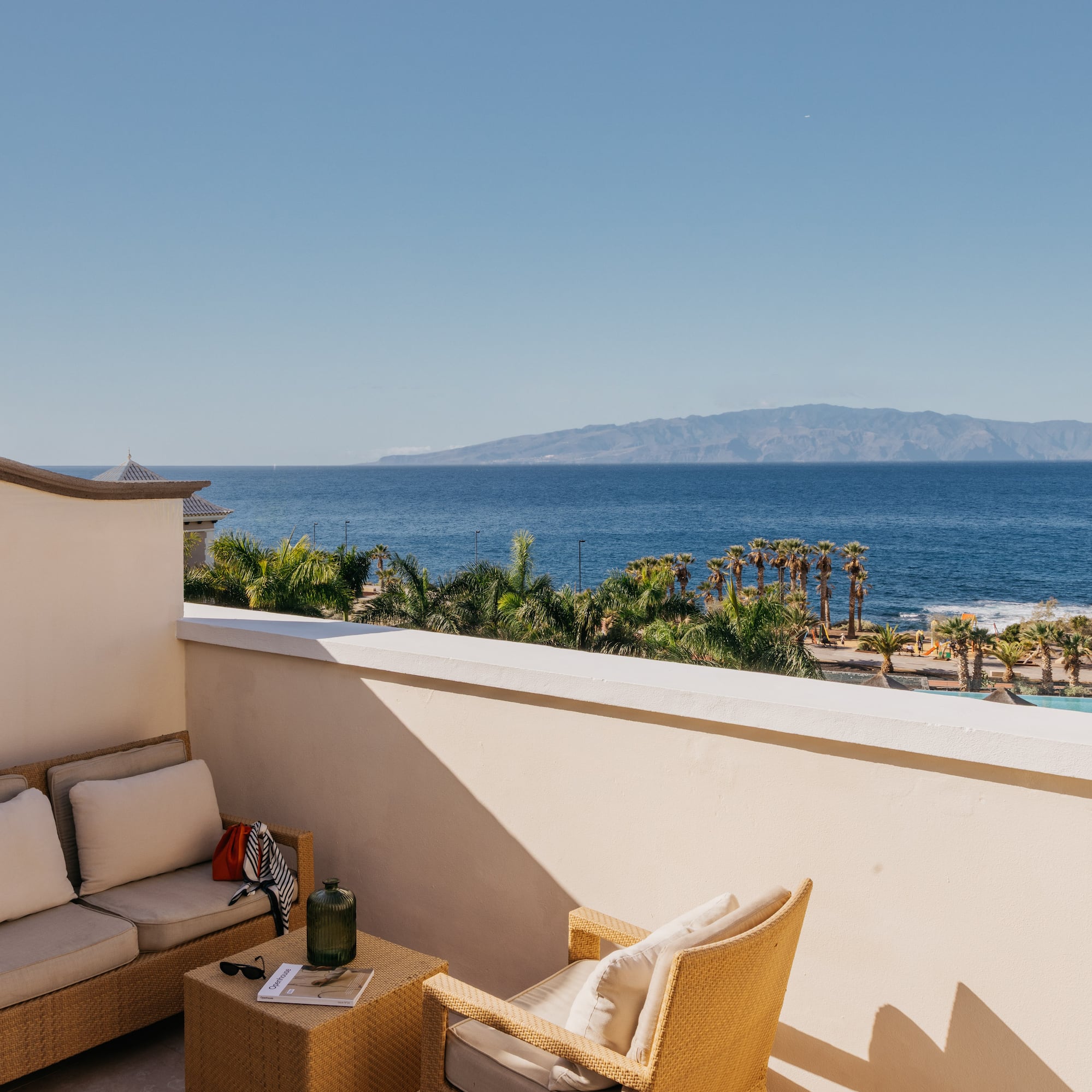 a balcony with a view of the ocean and a couch and a table