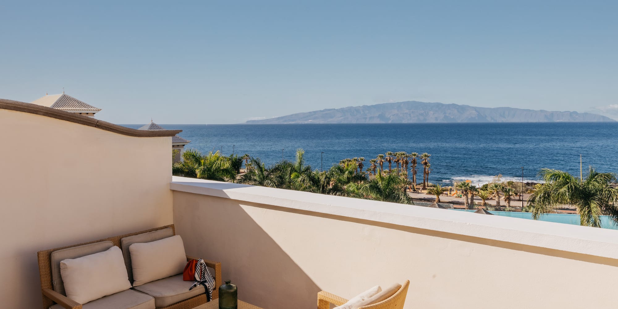 a balcony with a view of the ocean and a couch and a table