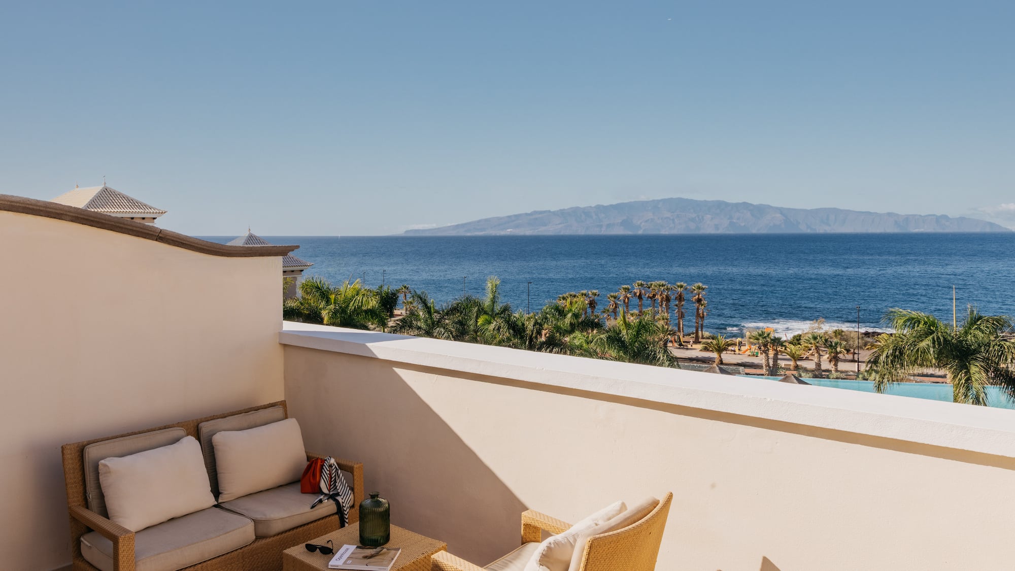 a balcony with a view of the ocean and a couch and a table